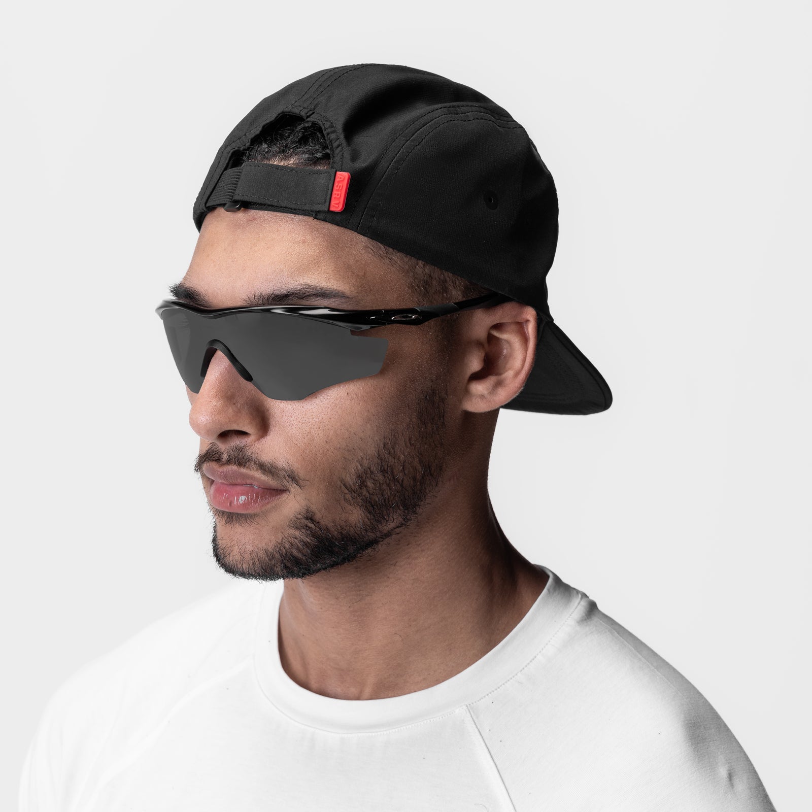 Black 5-panel run cap worn by model, side profile view