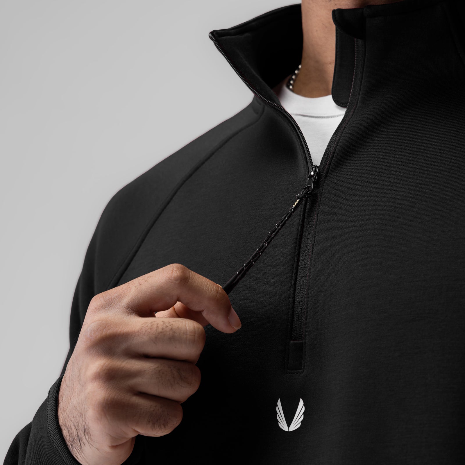 Black Dri-Core Quarter Zip worn by model, front view with hand on chest