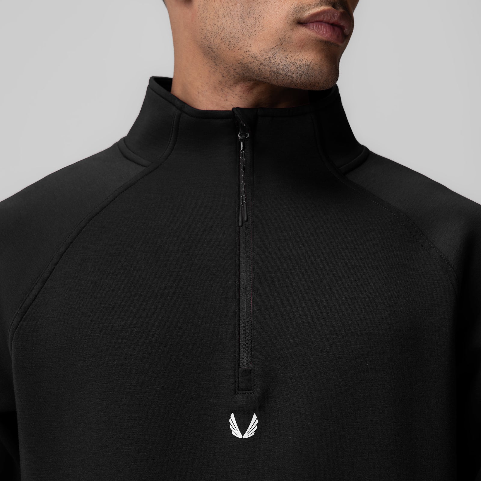 Dri-Core Quarter Zip in black worn by model, front detail view showing zipper and winged logo