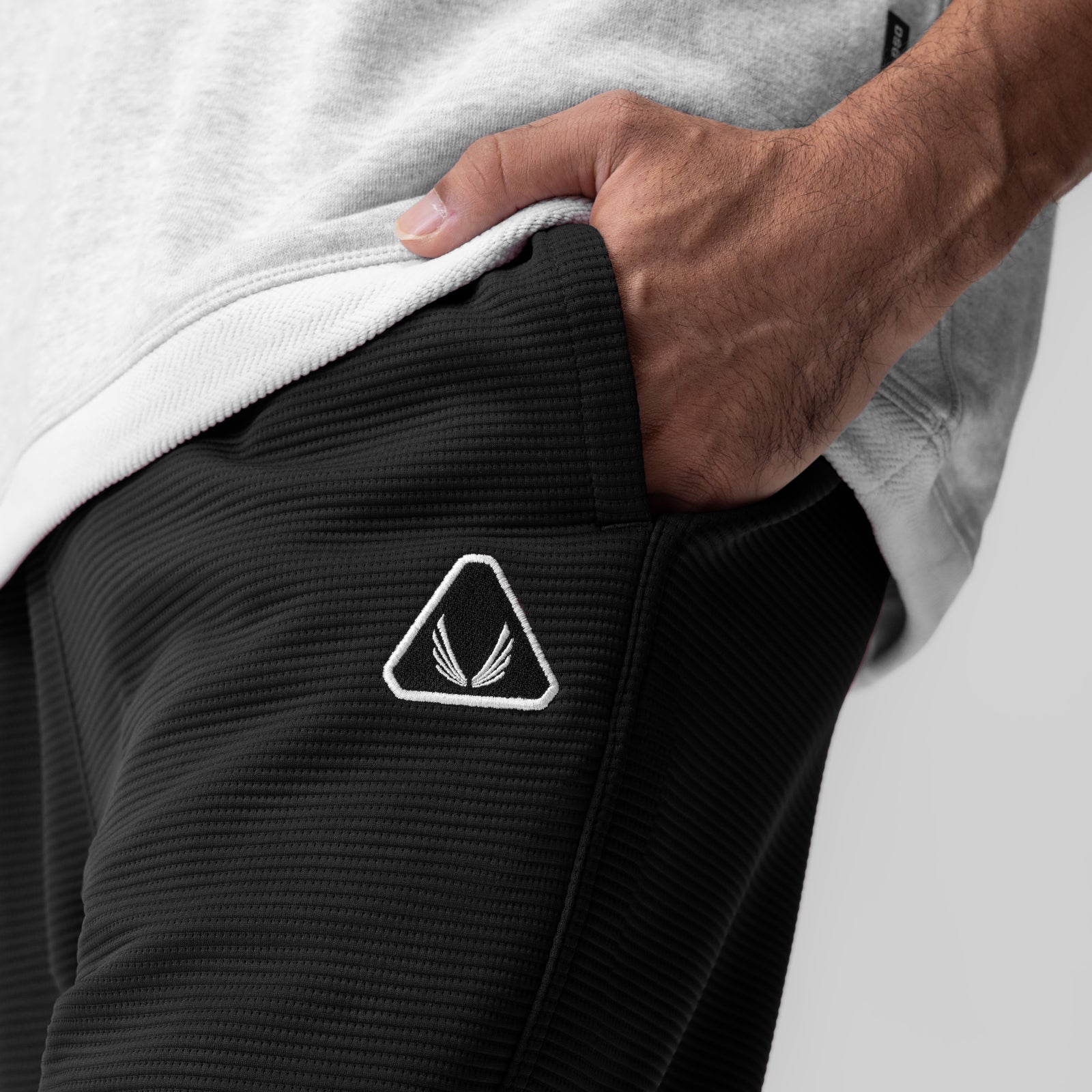 Deltapeak® Straight Leg Sweats in black, worn by model showing side pocket detail with triangular logo