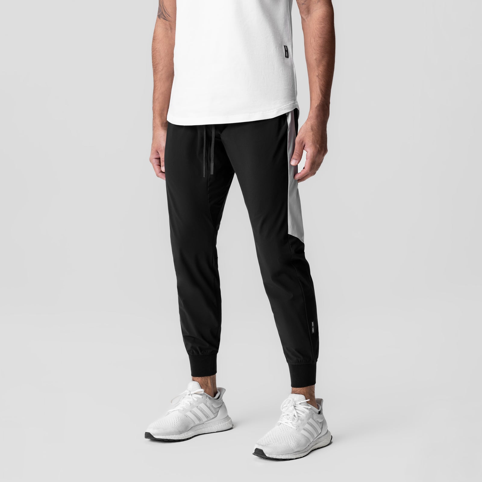 Tetra-Lite Cuffed Training Jogger in black, worn by model with white sneakers, front view