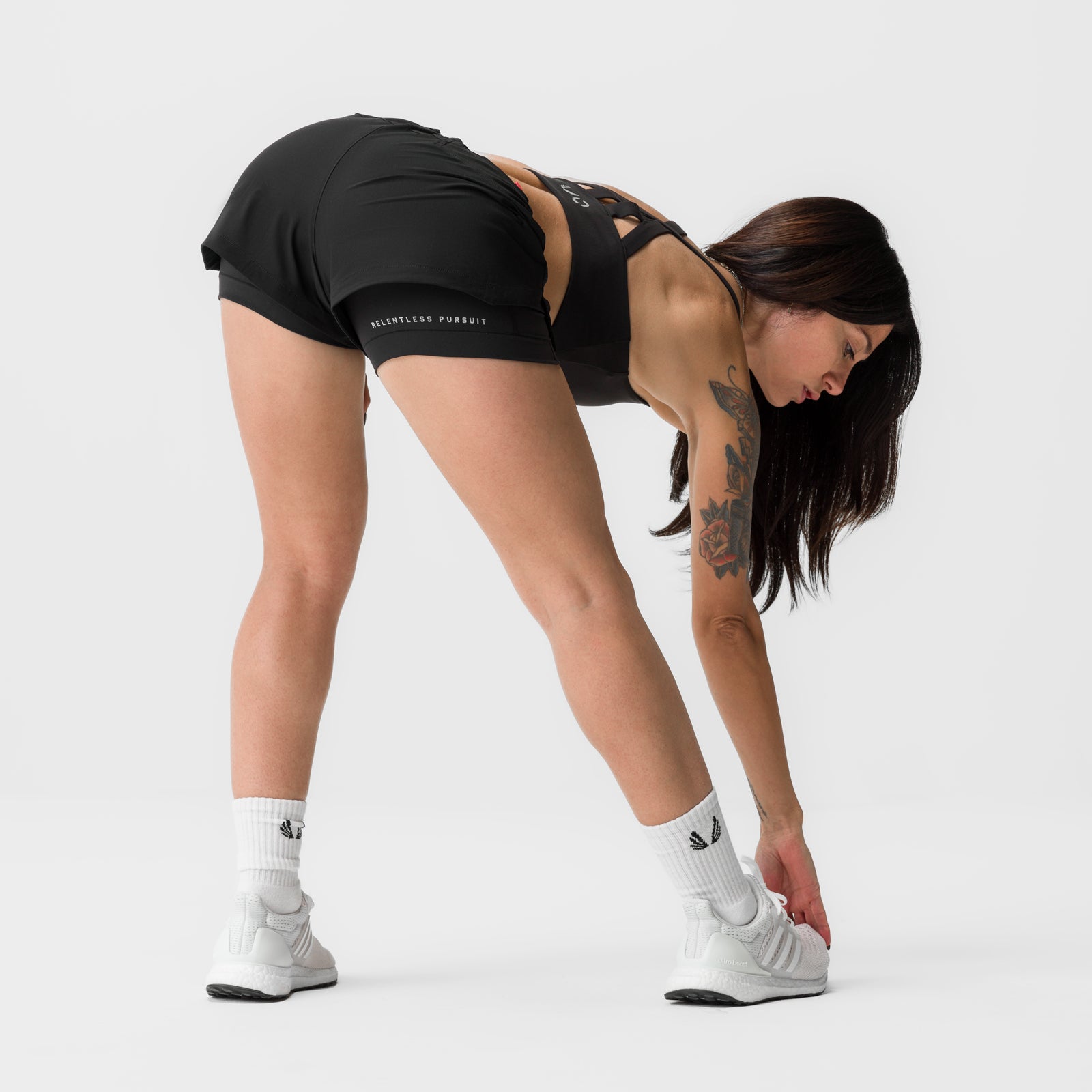 Black Tetra-Lite 4" liner shorts worn by model bending forward, front view