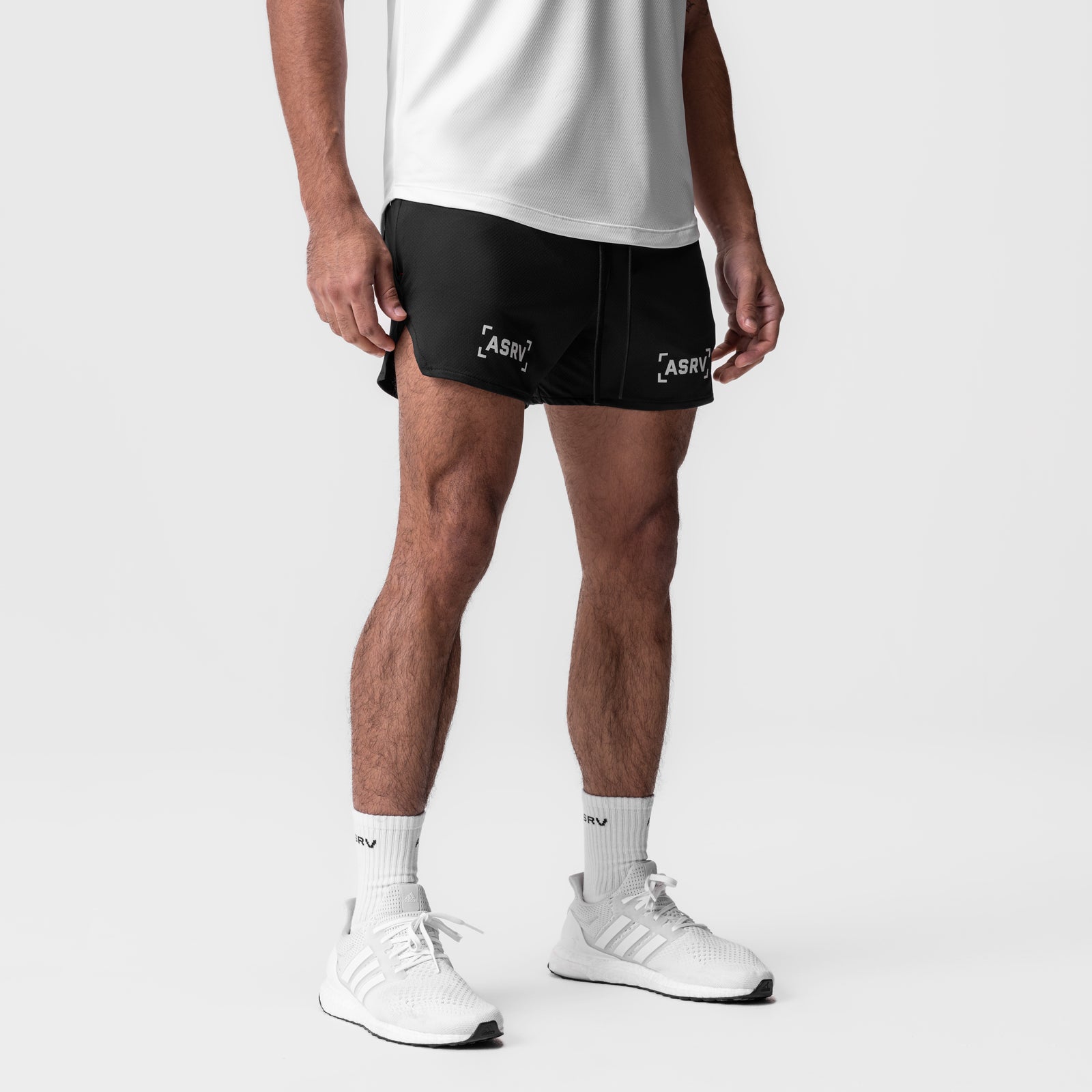 AeroSilver 5" linerless shorts in black with brackets logo, worn by model with white sneakers