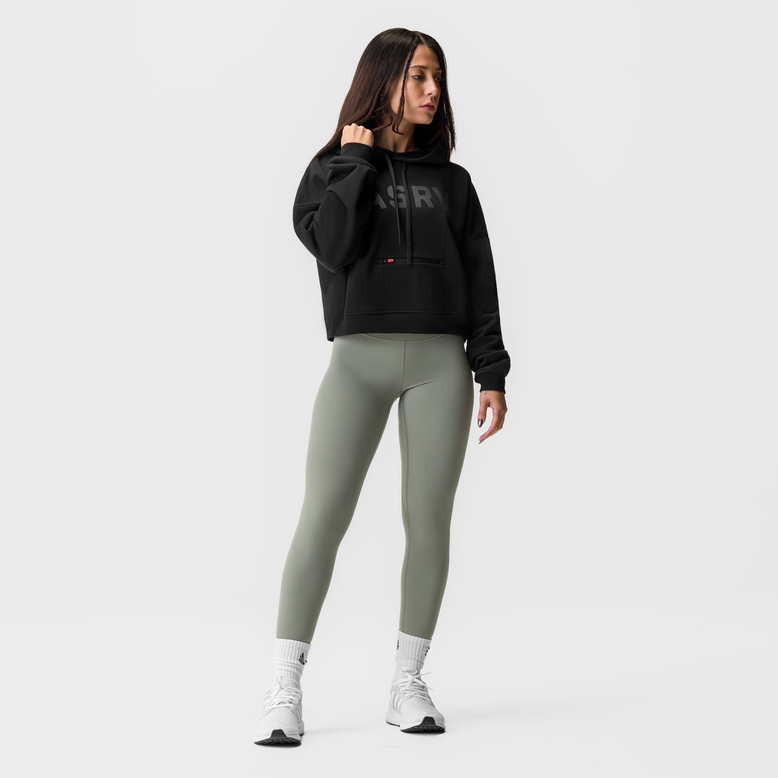 Black cropped hoodie styled with sage green leggings and white socks, front view on model