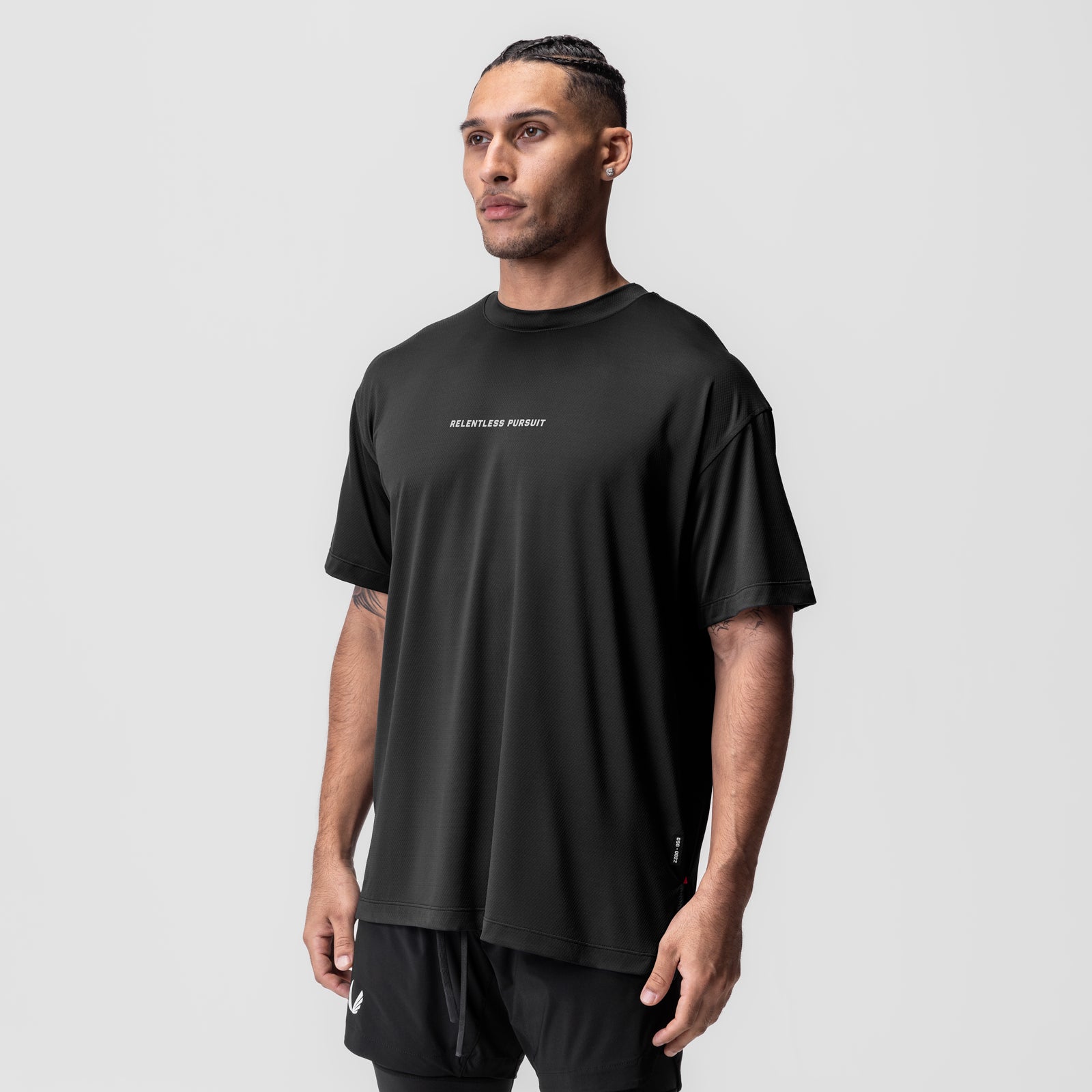 AeroSilver Oversized Tee in black with 'Relentless Pursuit' text, modeled front view