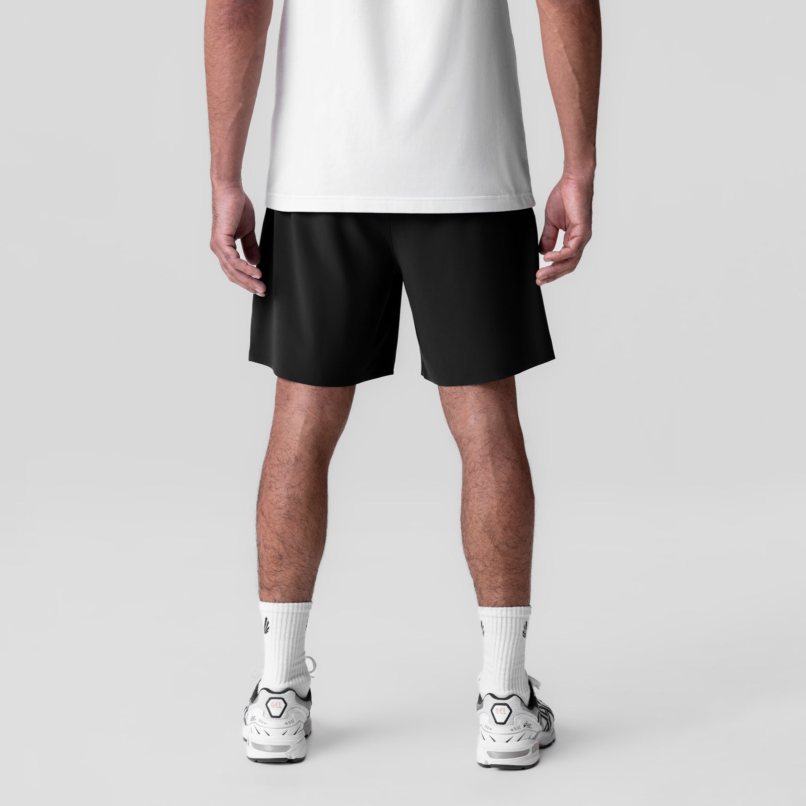 Black Revolutional Field Shorts worn with white socks and sneakers, back view