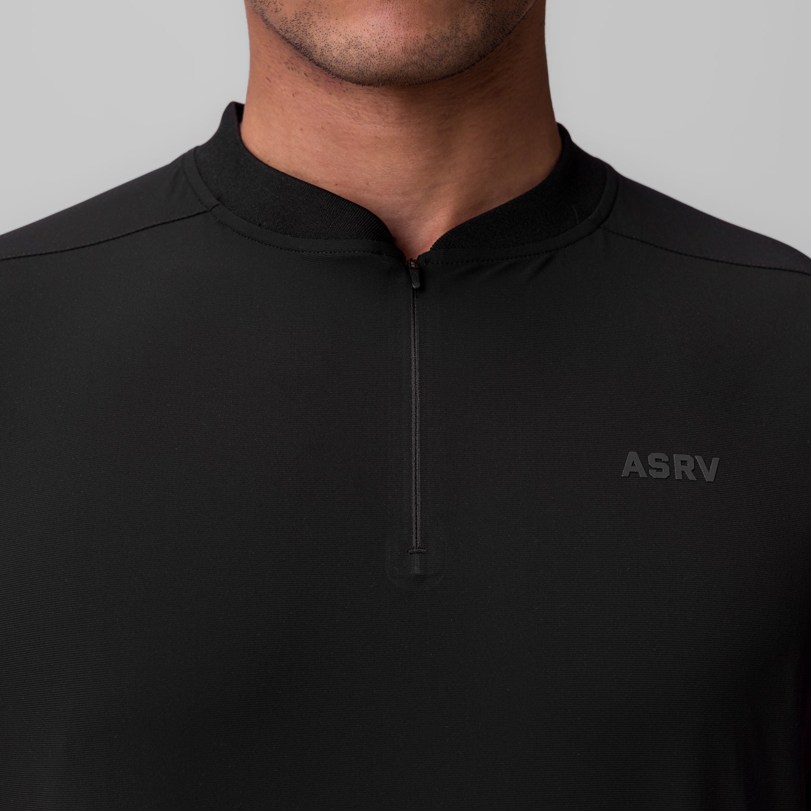 Black Tetra-Lite Ice Zip Tee worn by model, front view showing quarter-zip neckline and ASRV logo