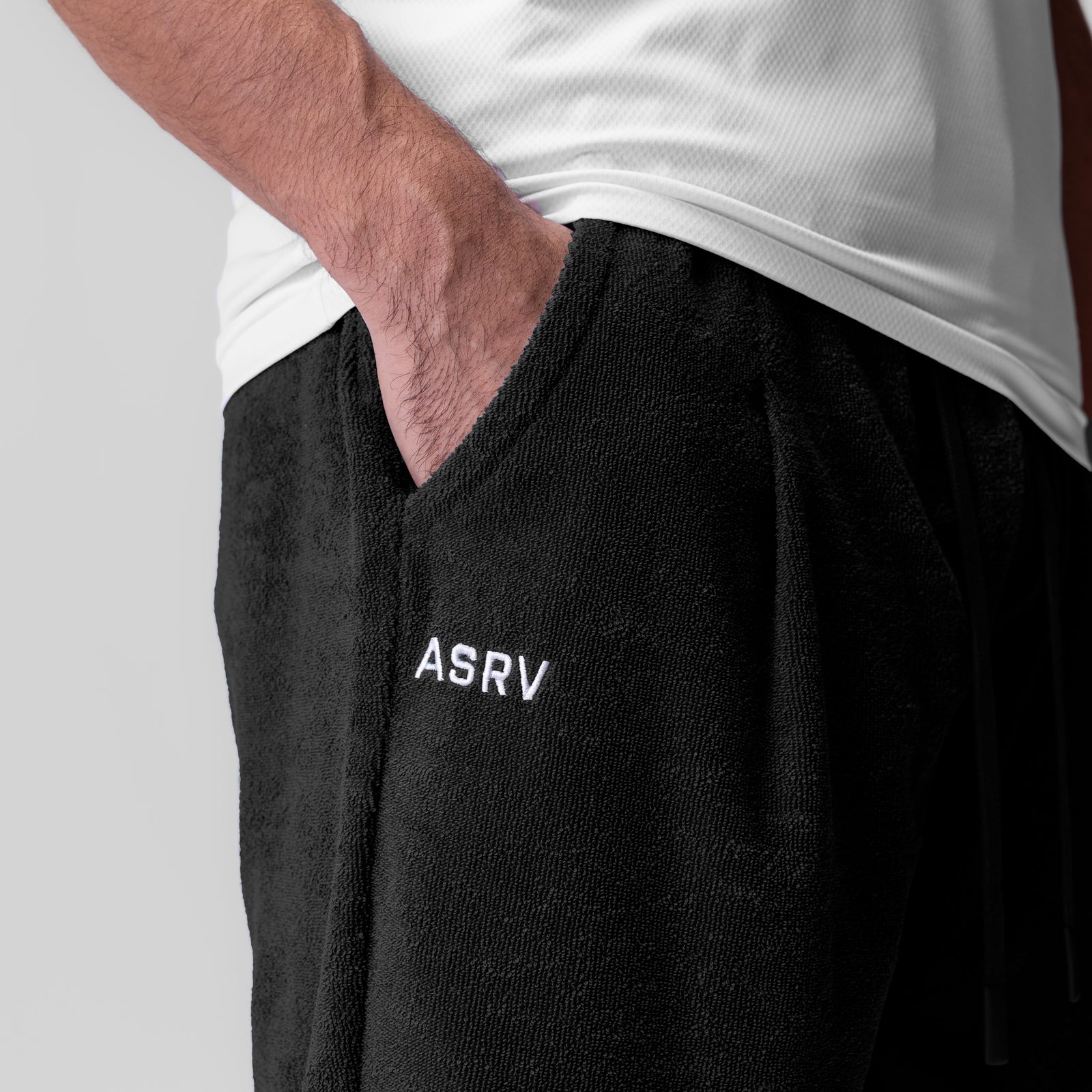 Towel Terry Relaxed Short in black, worn by model with hand in pocket, side view