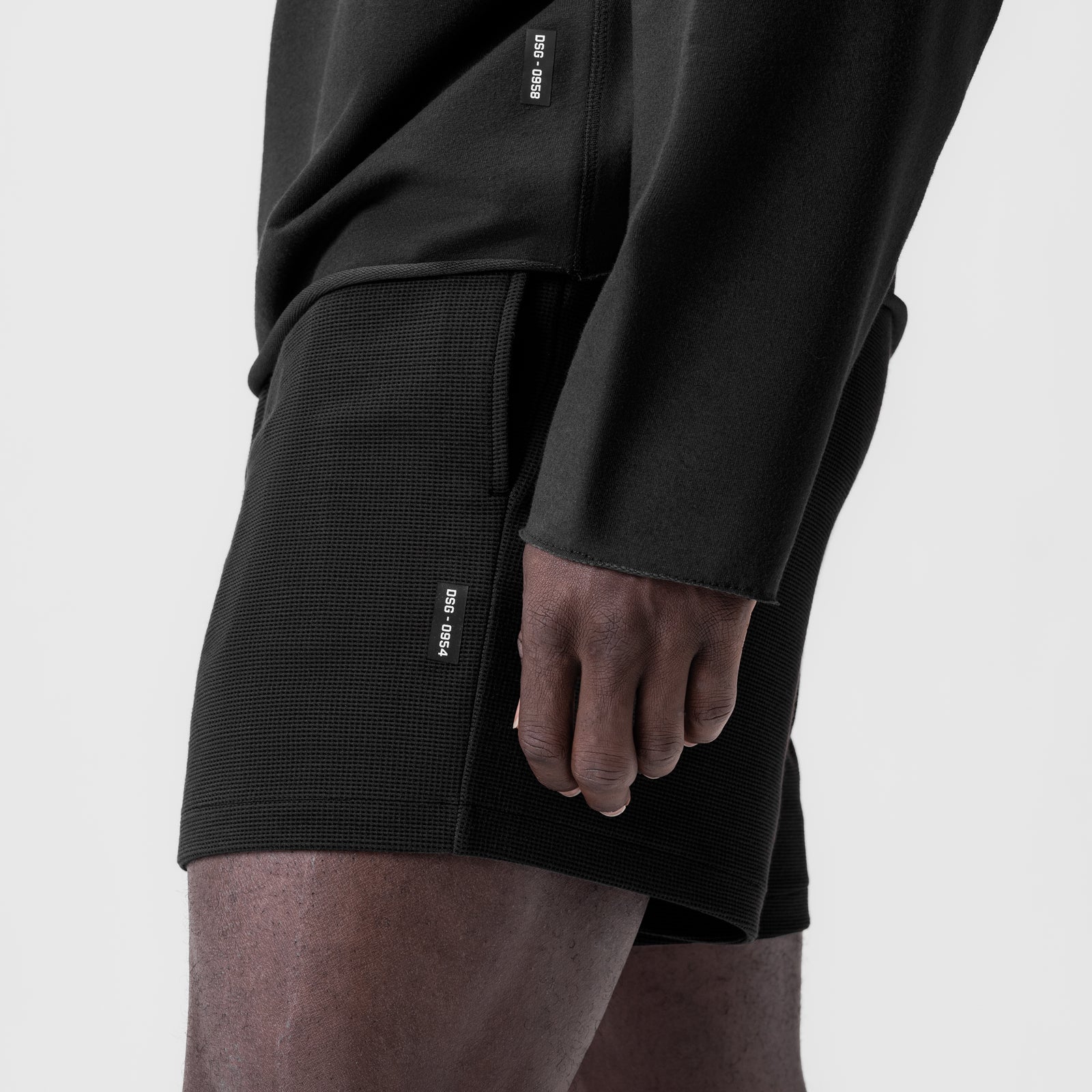Black waffle knit sweat shorts worn by model, side view showing fit and texture detail