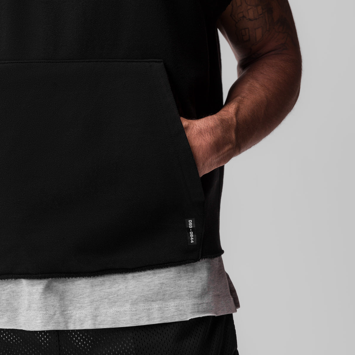 Black Tech Essential Raw Hem Cutoff Hoodie worn by model, side view showing pocket detail