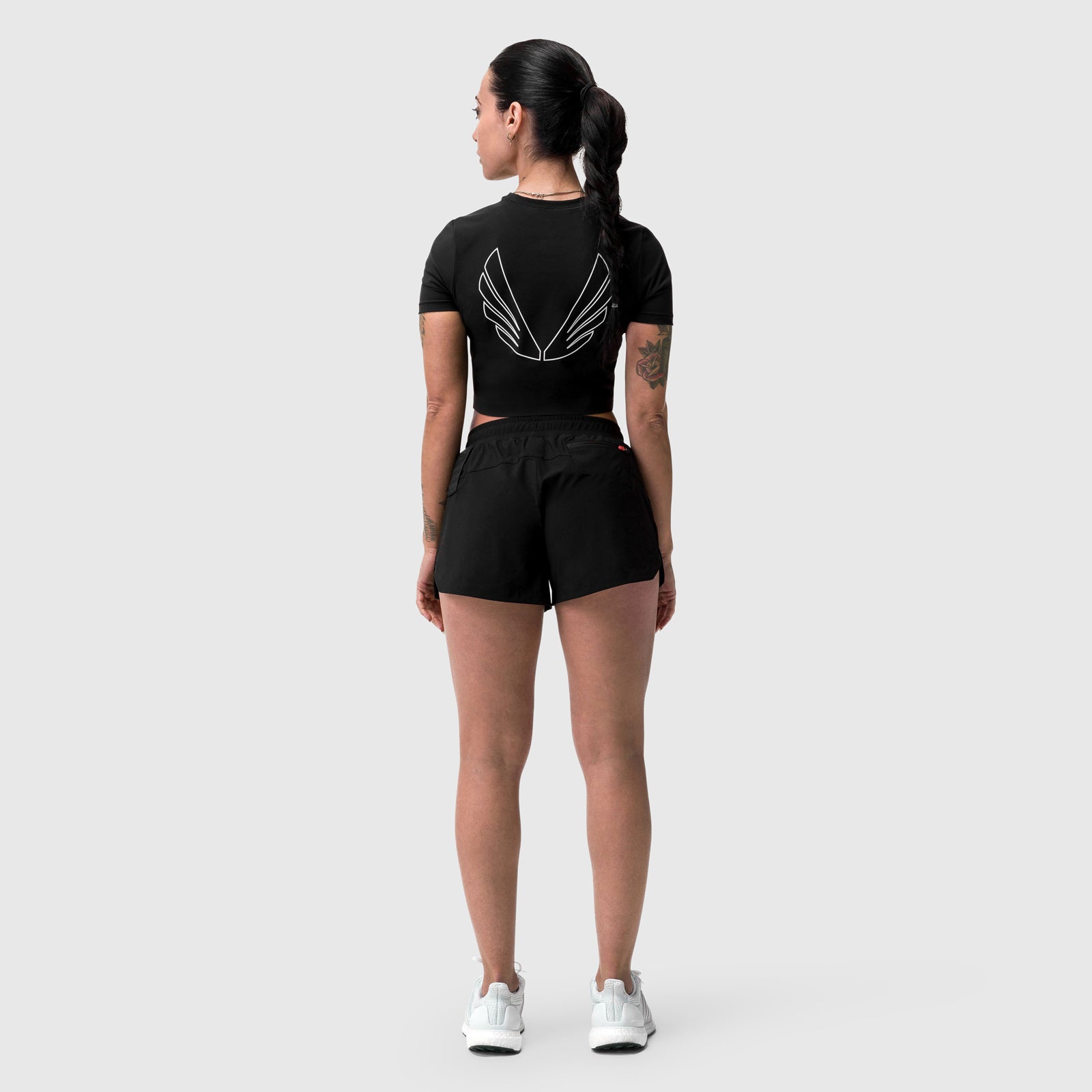 W019 Lycra Cropped Tee in black with 'Big Wings' design, worn by model, back view