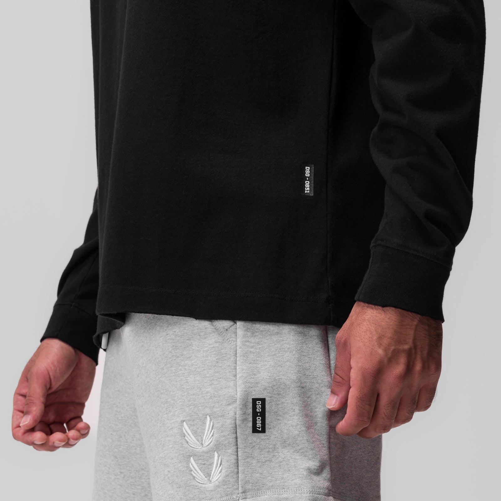 Tech Essential Relaxed Long Sleeve in black worn with grey joggers, detail view