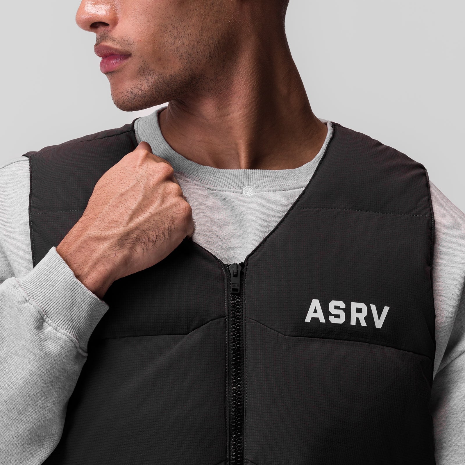 Black ripstop insulated puffer gilet worn over grey long-sleeve shirt, front view