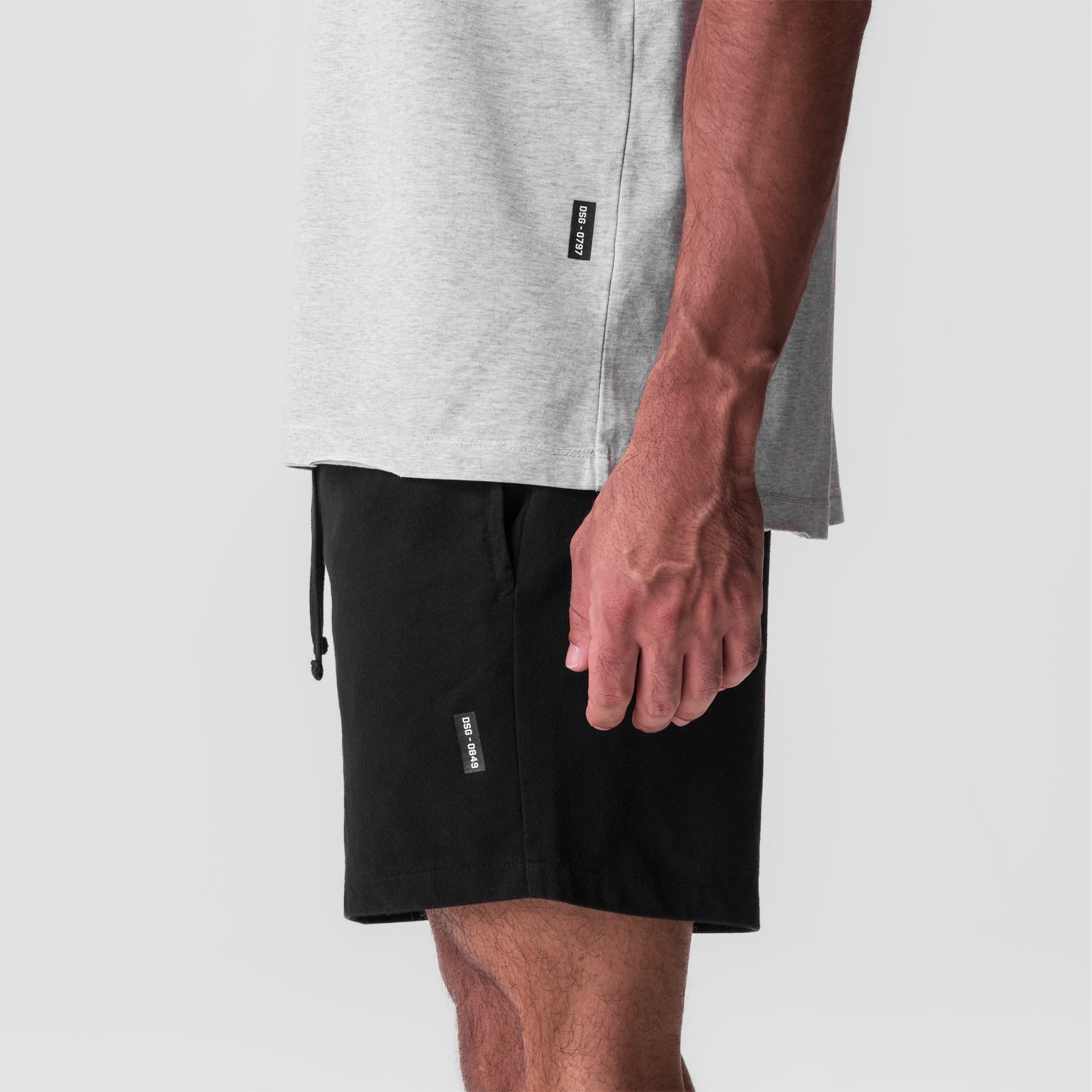 Tech Essential Sweat Short in black, worn with grey t-shirt, side view