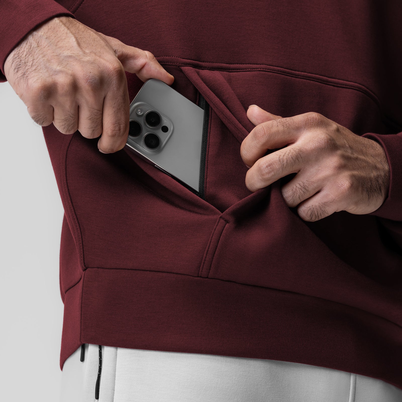 Dri-Core™ Oversized Crewneck in crimson worn by model placing phone in pocket