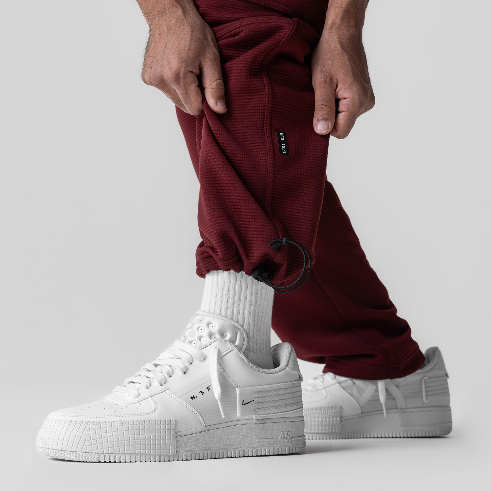 Deltapeak® Cargo Cinch Jogger in crimson worn with white socks and sneakers, side view