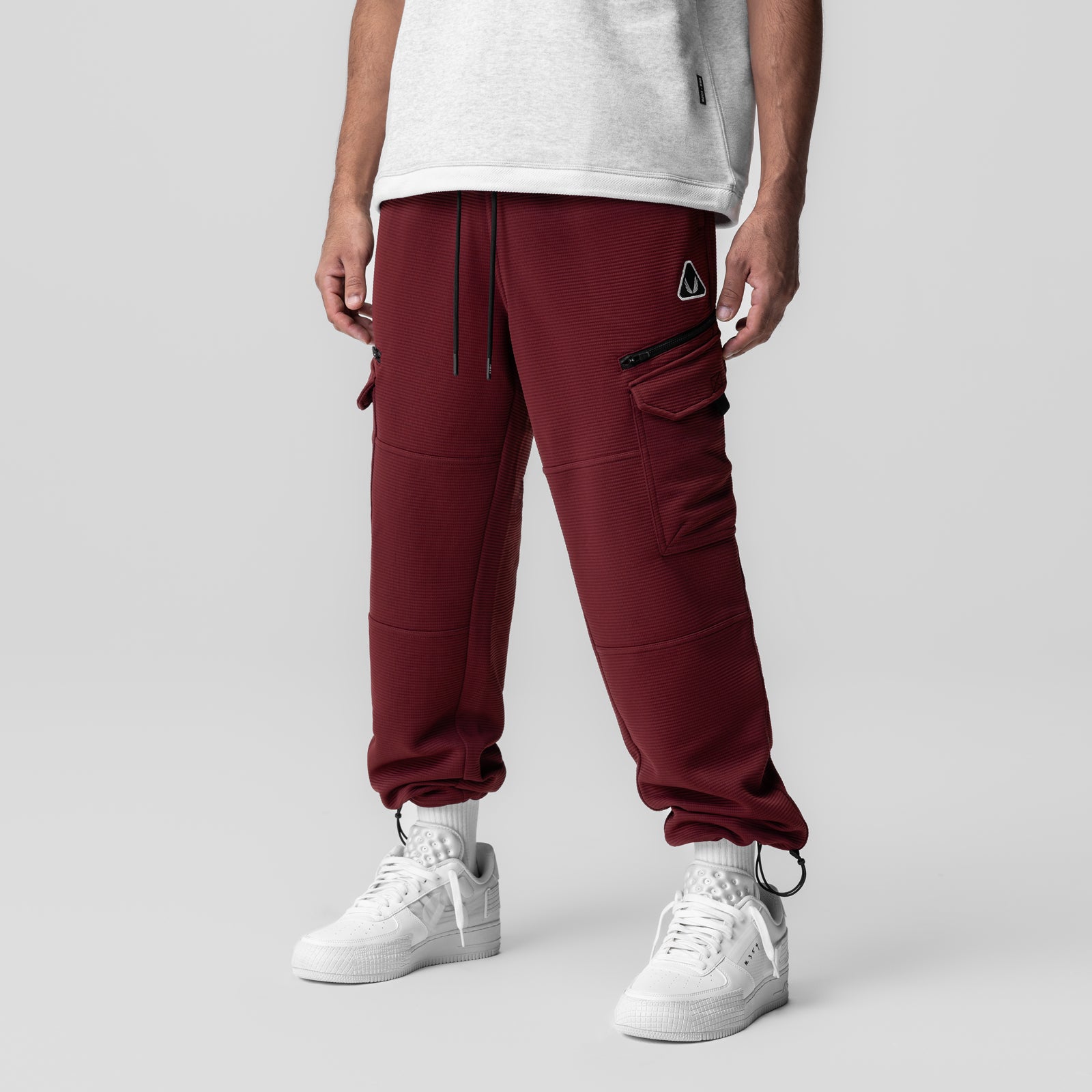 Deltapeak Cargo Cinch Jogger in crimson worn by model with white sneakers, front view