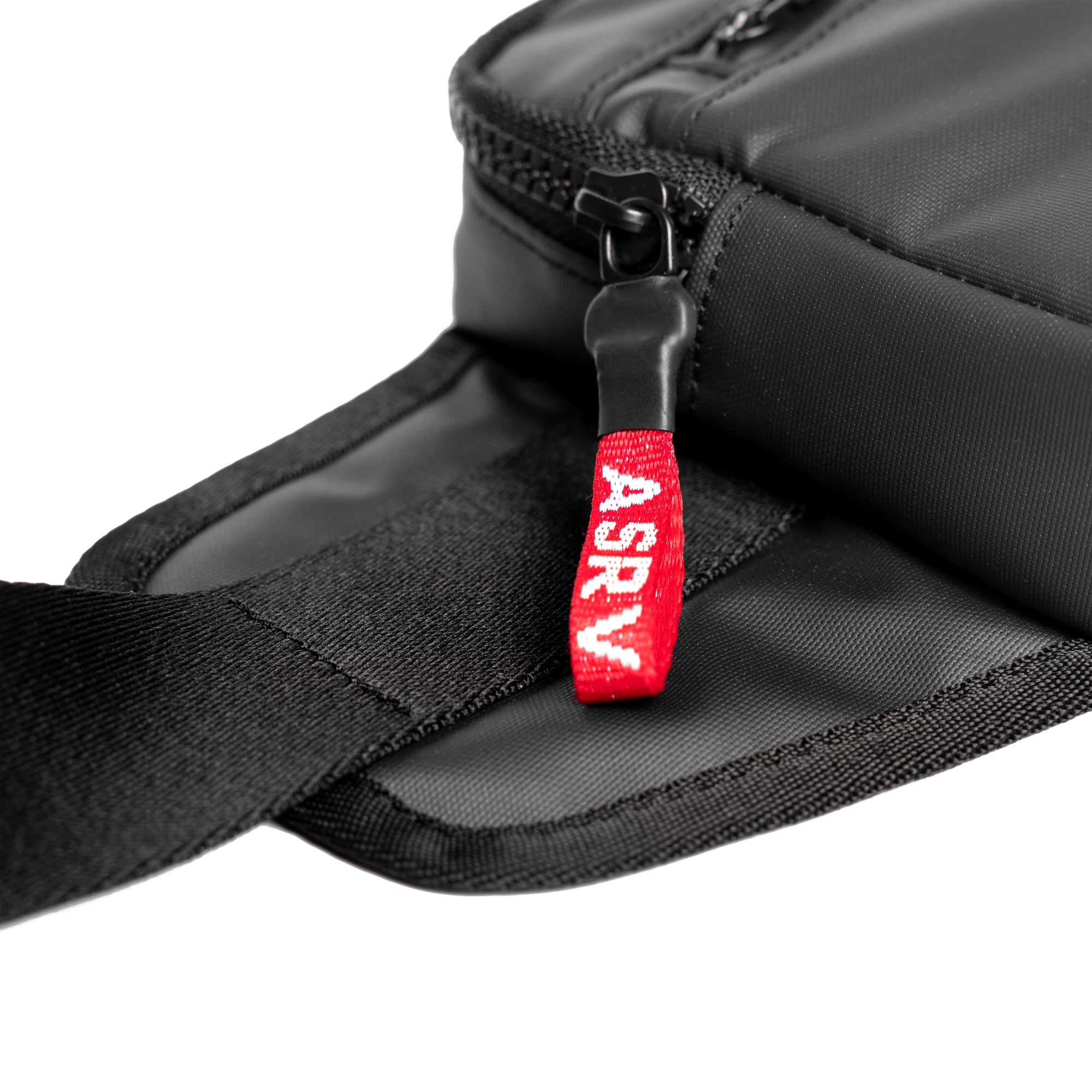 Flatlay water resistant small crossbody bag in black with red zipper pull detail