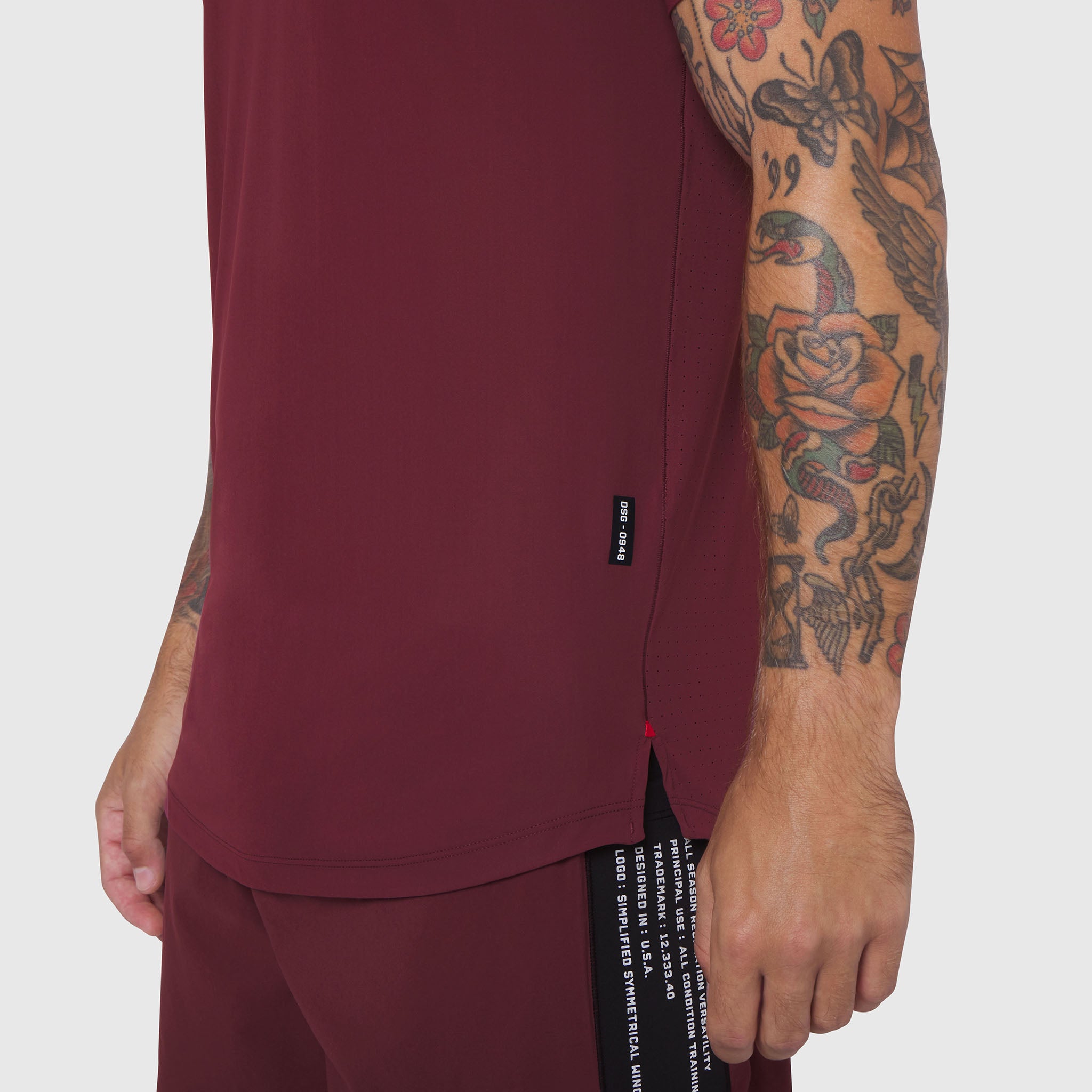 Laser-Vent Established Tee in Crimson worn by model showing side view with tattoos visible