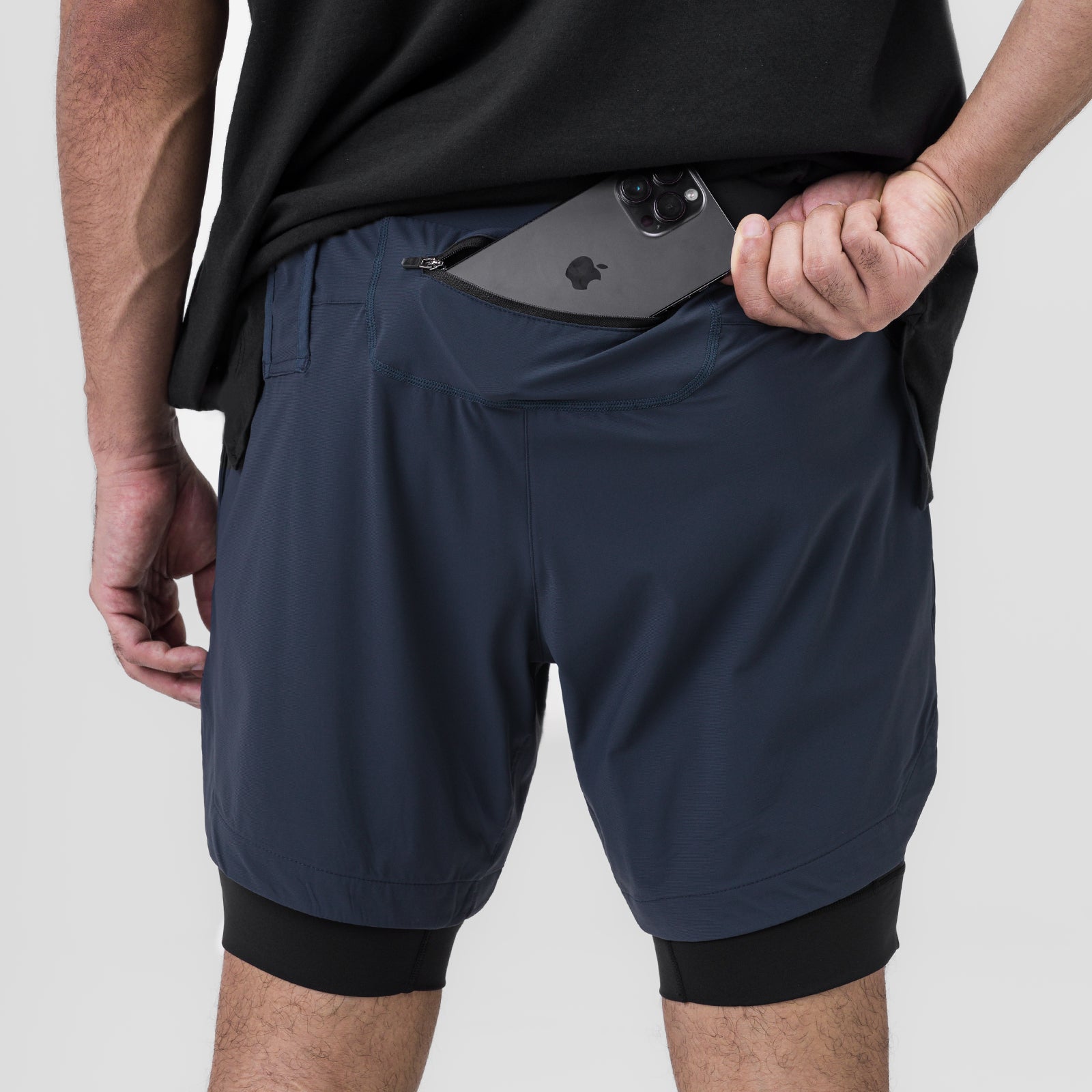 Tetra-Lite 7" Liner Short in navy and black, worn by model holding phone in front pocket