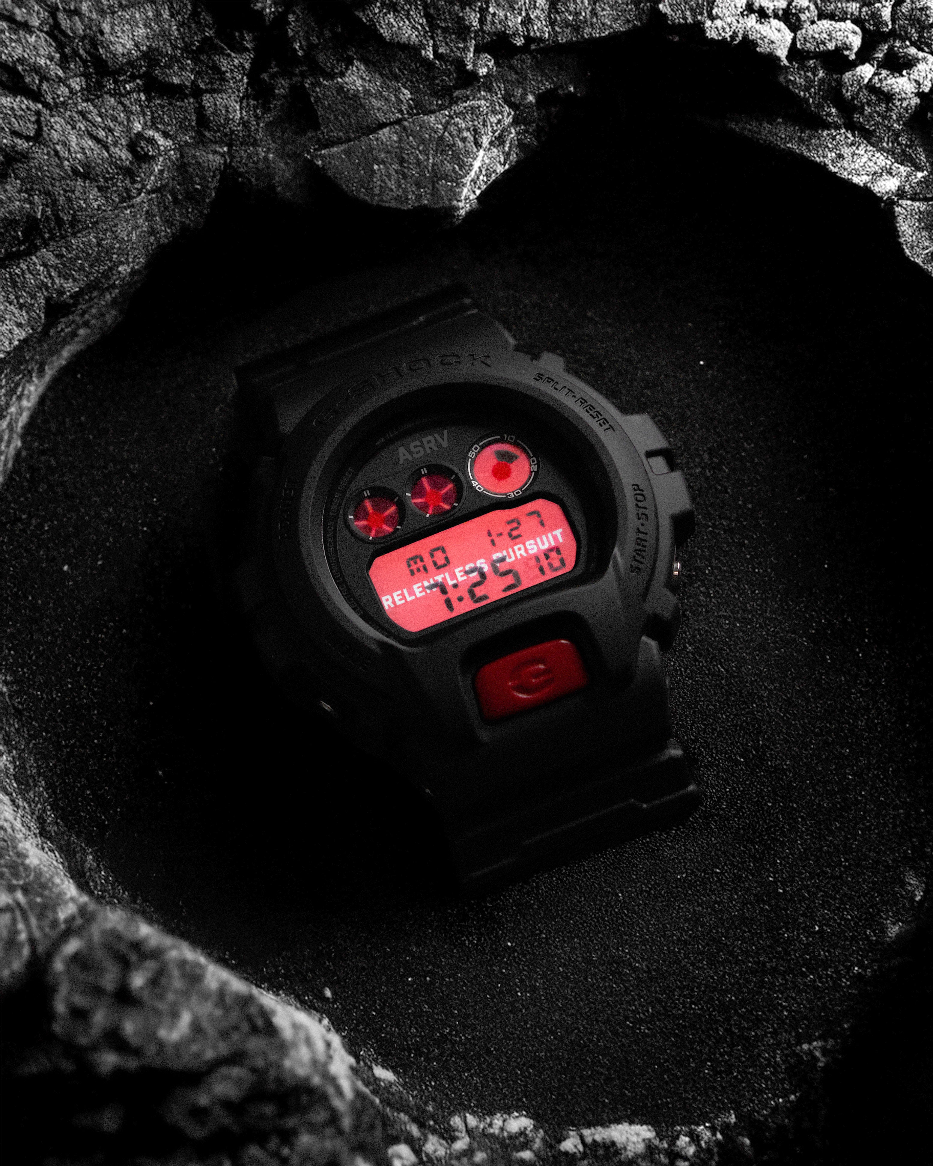 ASRV x G-SHOCK DW6900 digital watch with red display on black surface, overhead view
