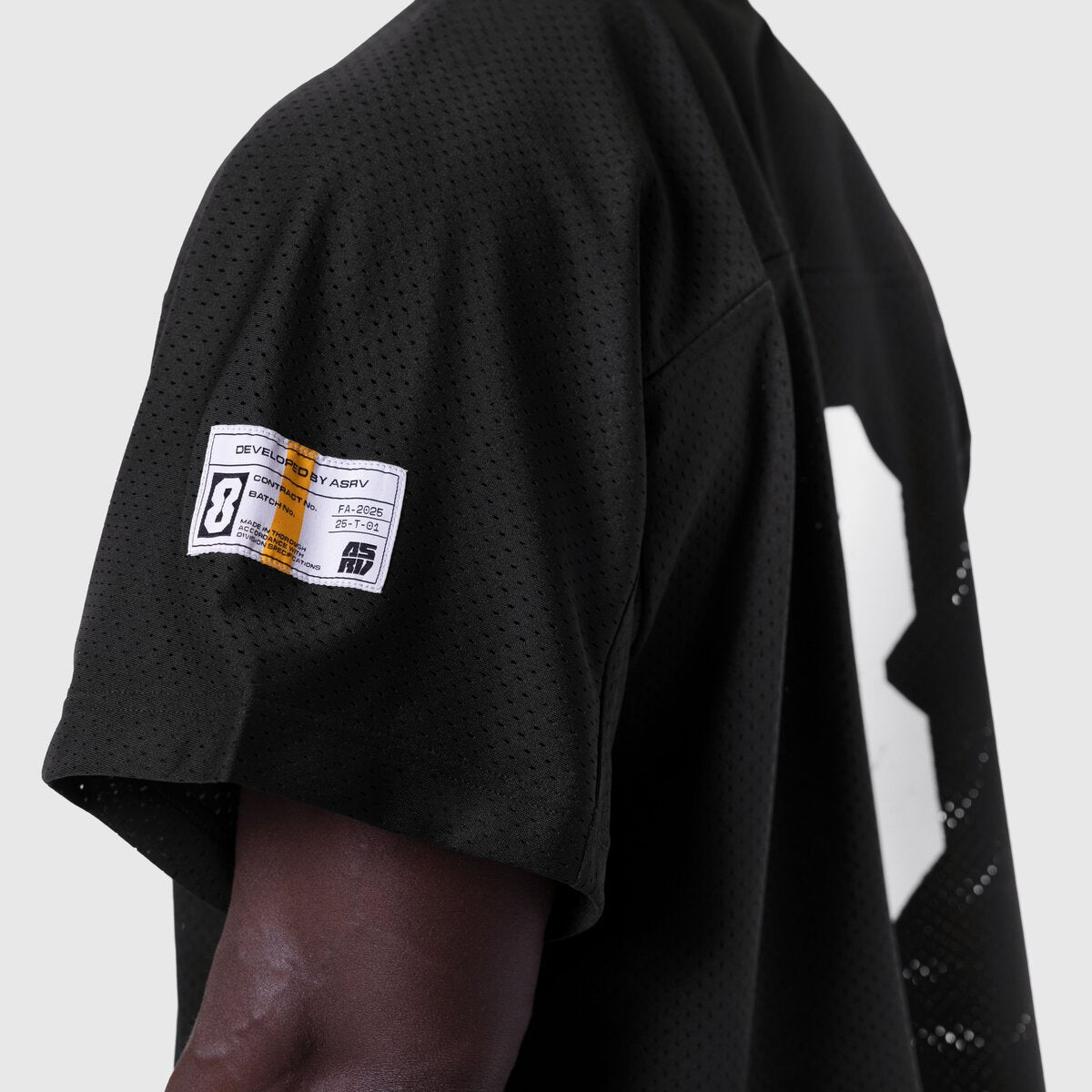 Ion-Mesh Crop Jersey in black worn by model, side view showing perforated mesh fabric and brand label