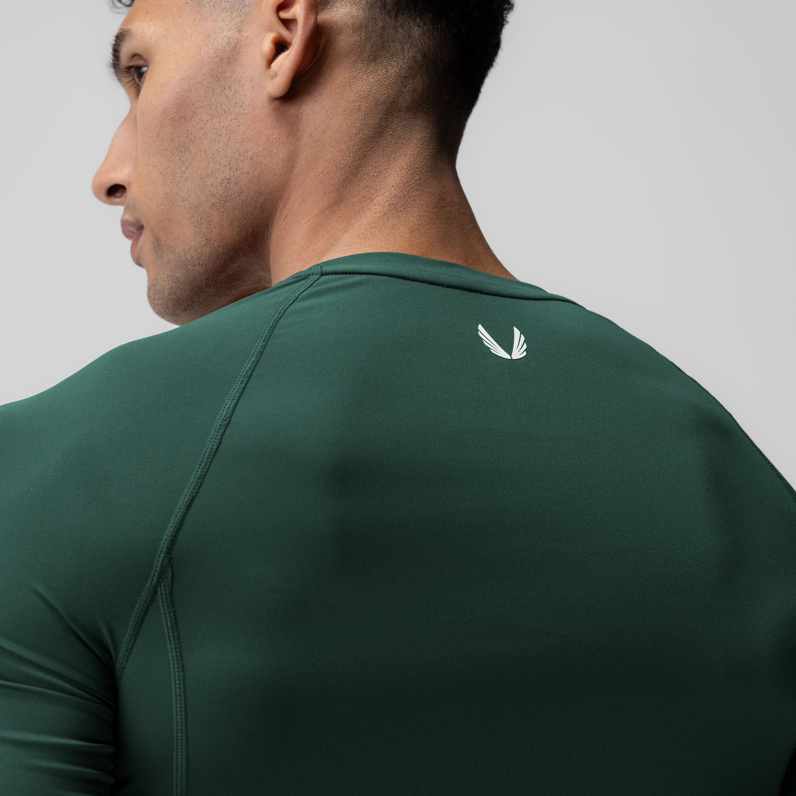 WarpFlexx-Lite® half-sleeve baselayer in forest green, worn by model shown from side profile