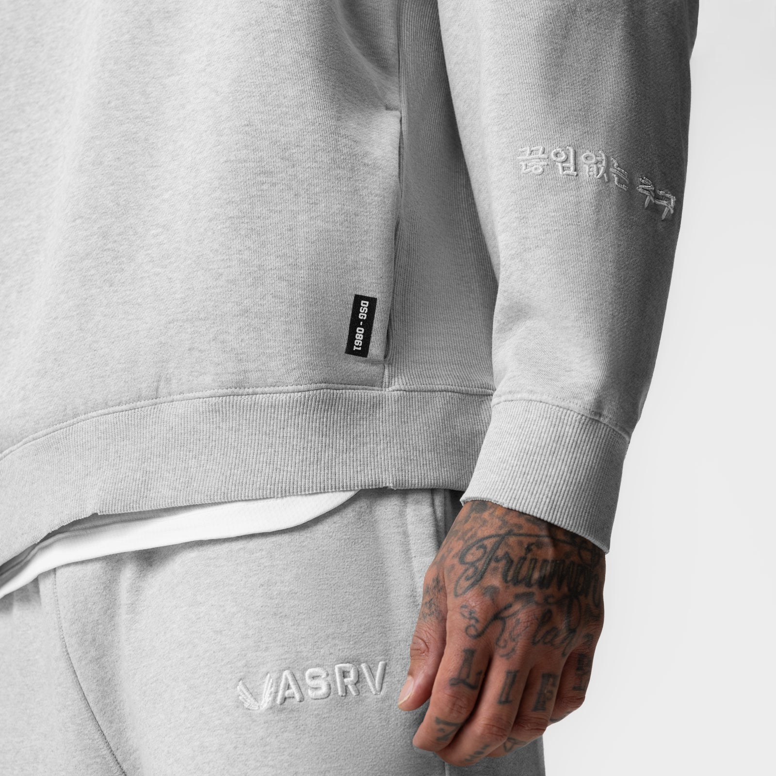 Tech Essential Distressed Crewneck in heather grey worn by model showing sleeve detail and branding