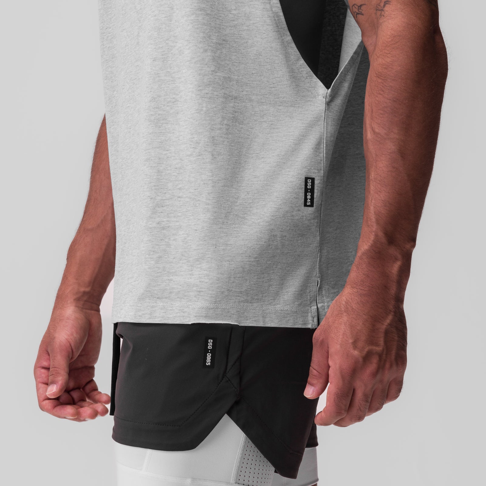 Tech Essential Rocker Cutoff tank in heather grey and black, worn by model