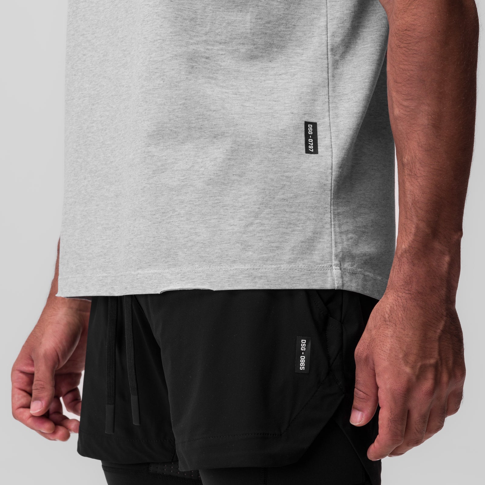 Tech Essential Relaxed Tee in heather grey worn by model, side view showing fit and length