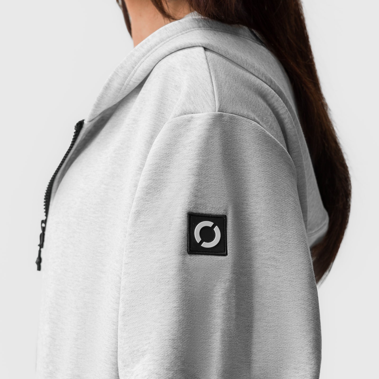 Heather grey oversized zip hoodie worn by model, side view showing branded patch