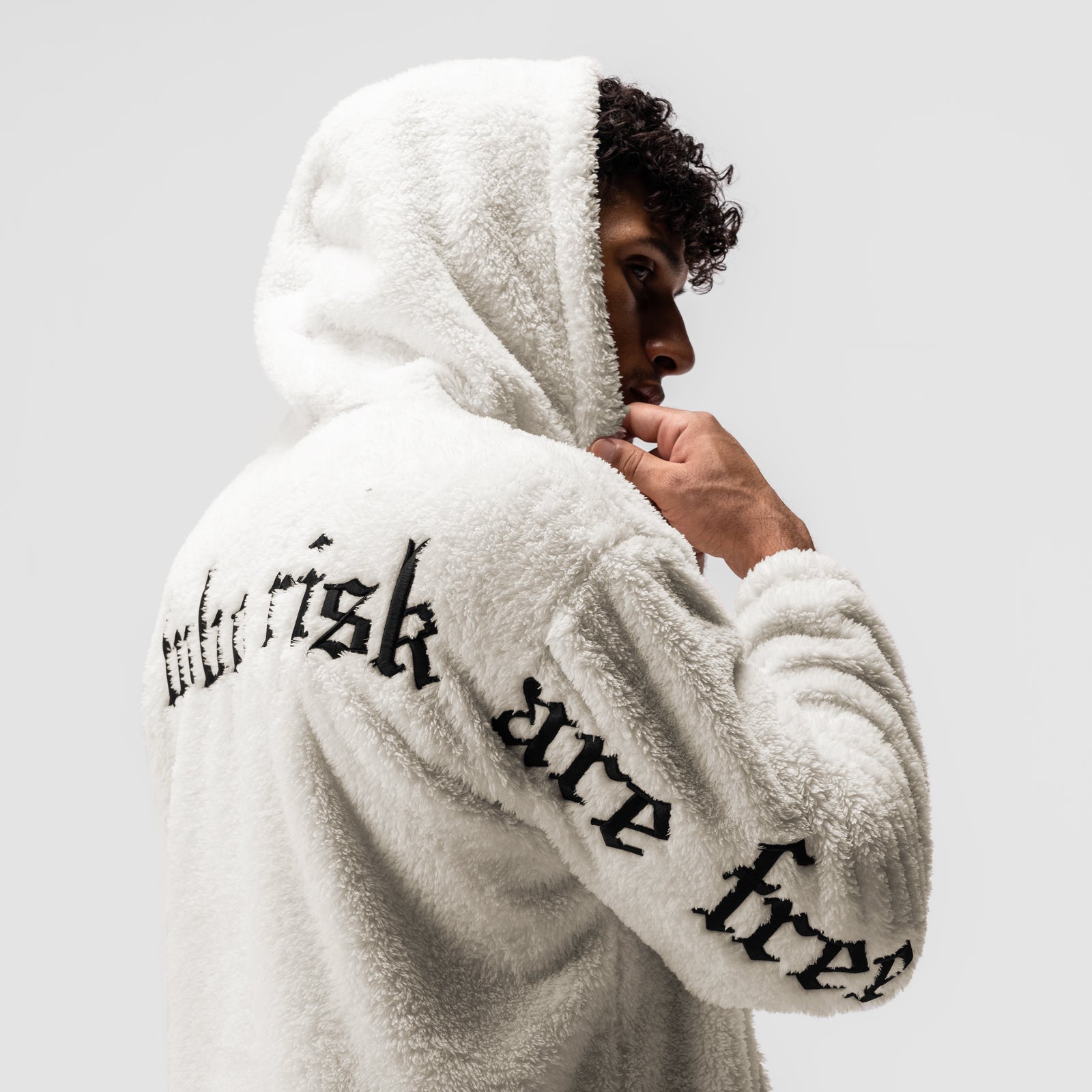 Sherpa Recovery Hoodie in ivory cream with black text, worn by model in profile pose