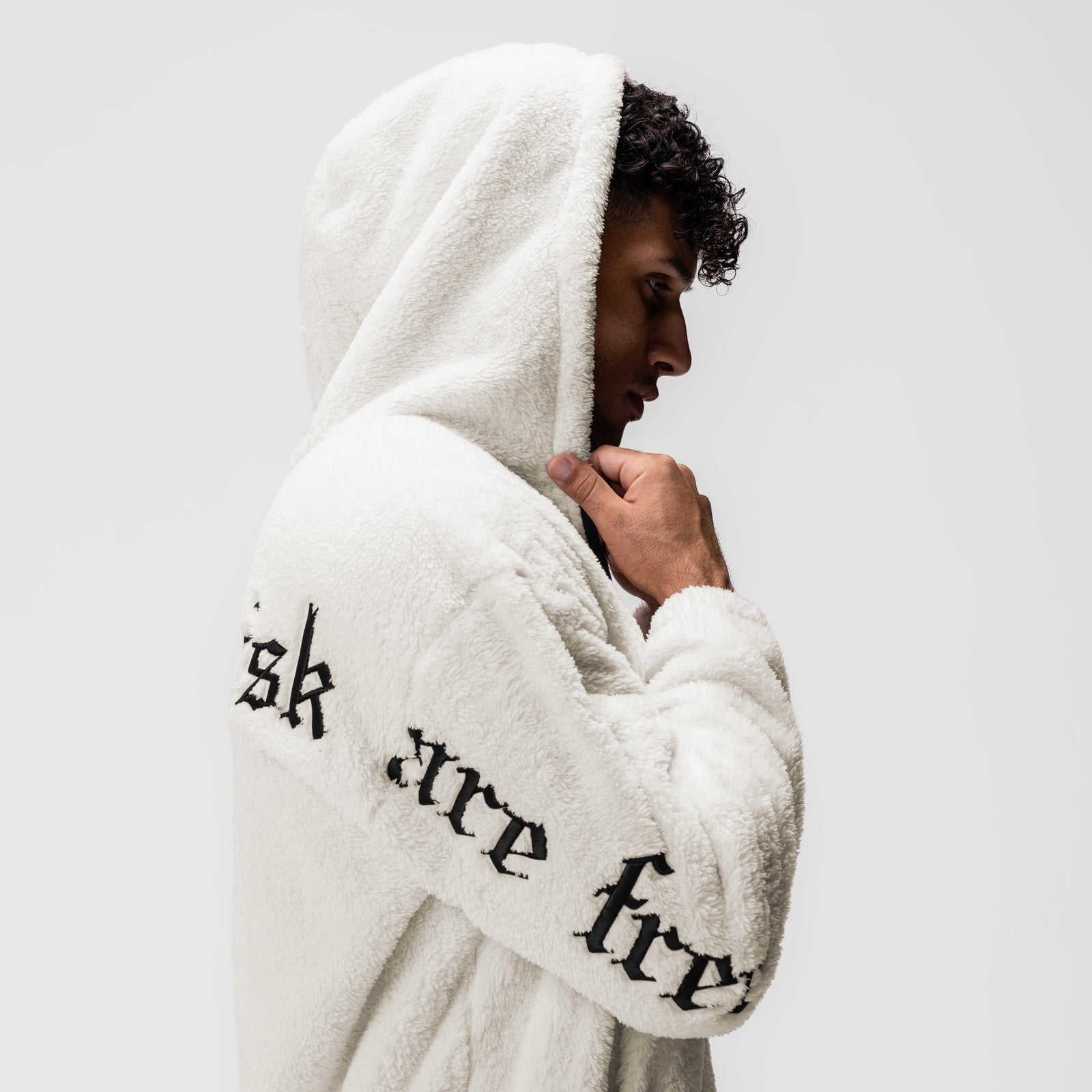 Sherpa Recovery Full Zip Hoodie in ivory cream with black text, worn by model in profile