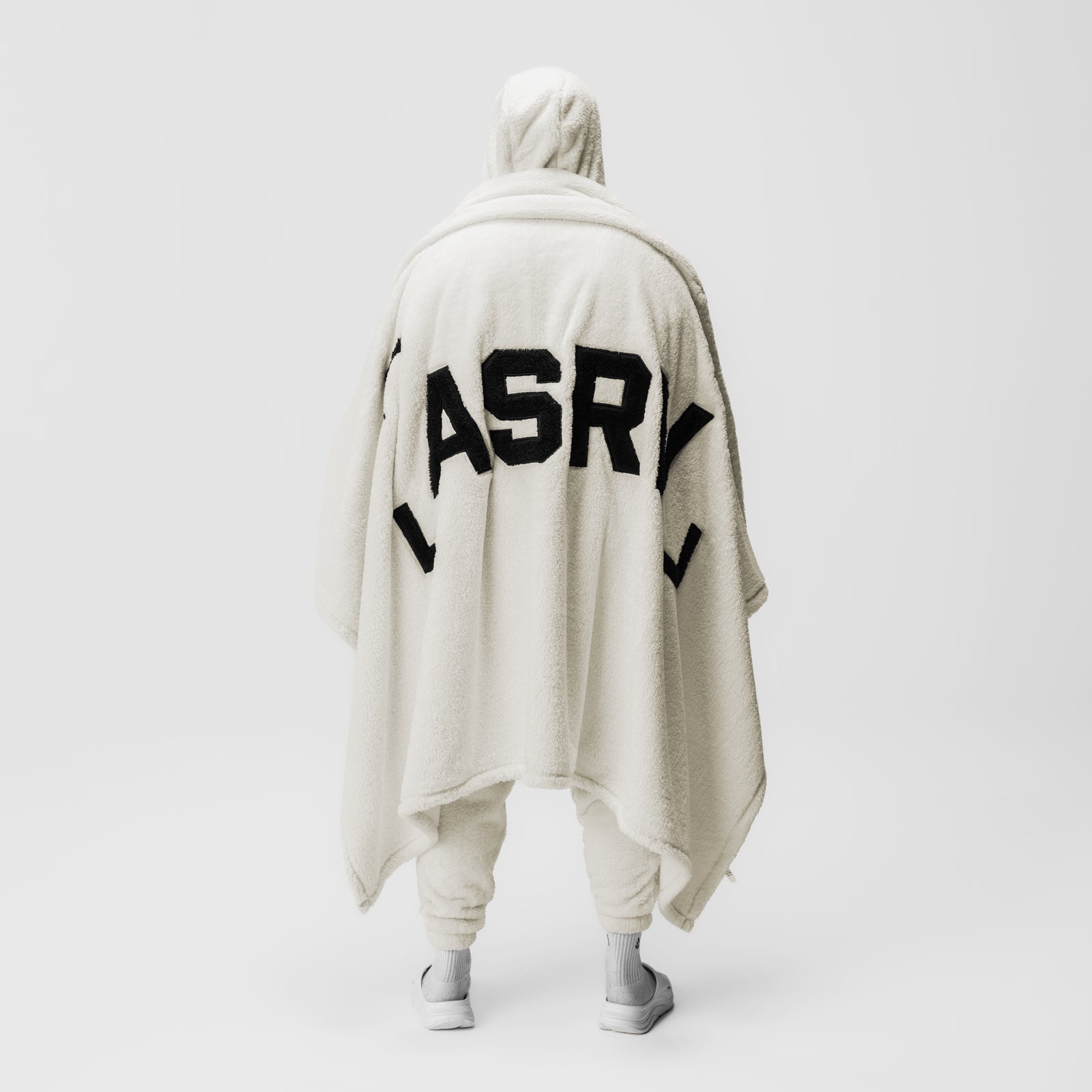 Sherpa Recovery Blanket in ivory cream with black ASR logo, worn as cape on model from behind