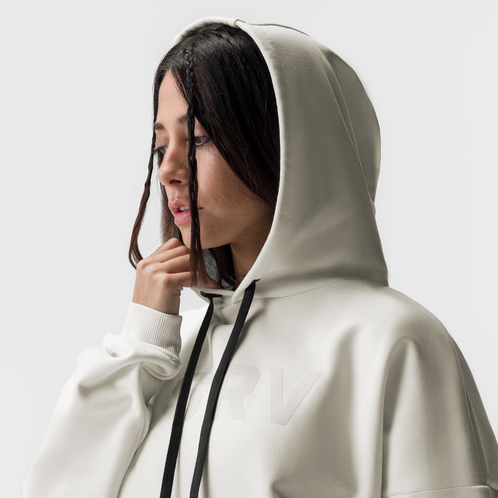 Ivory cream cropped hoodie worn by model in profile, hood up