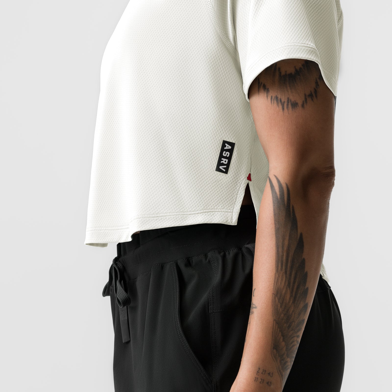 ASRV AeroSilver Cropped Training Tee in ivory cream worn by model, side view