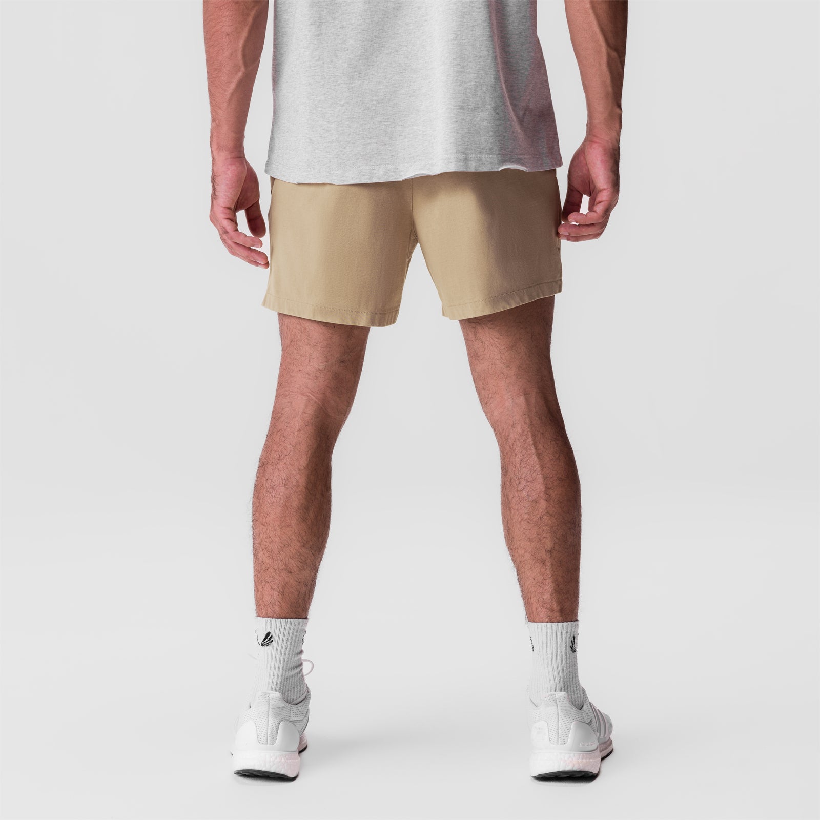 Tech Essential Sweat Short in khaki, back view on model wearing grey tank and white socks