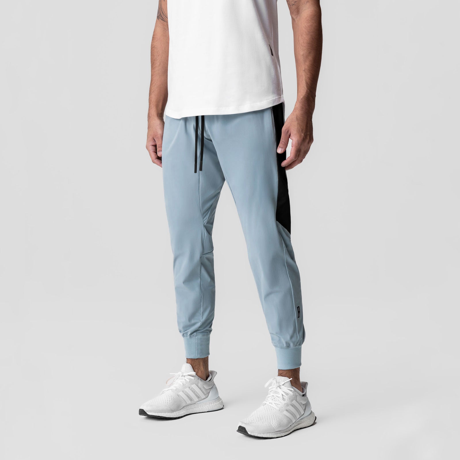 Tetra-Lite Cuffed Training Jogger in light sky, worn with white sneakers
