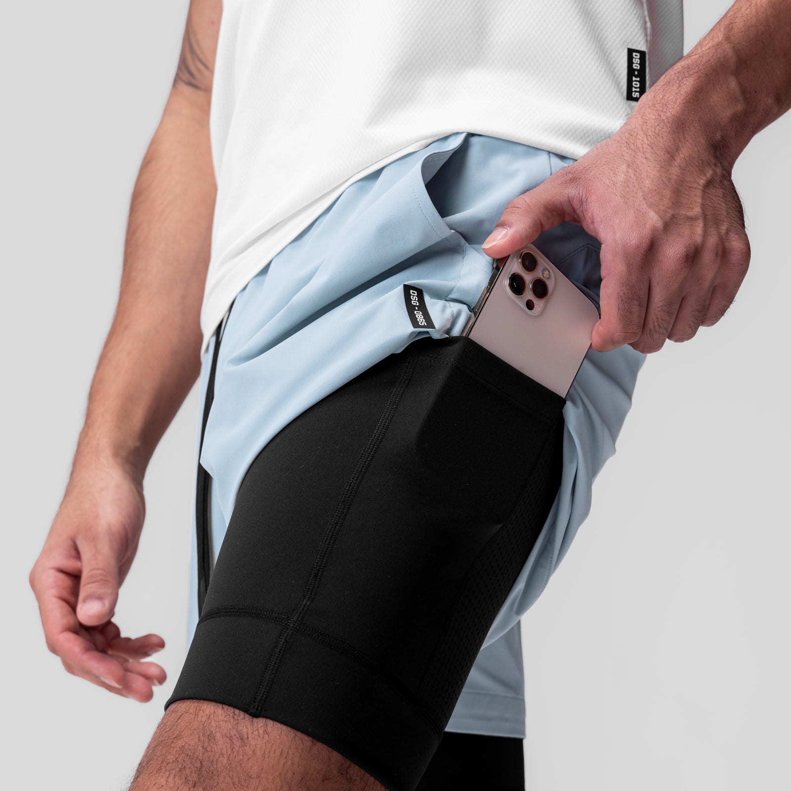 Tetra-Lite 5" Liner Short in Light Sky and Black, worn with model holding phone in pocket