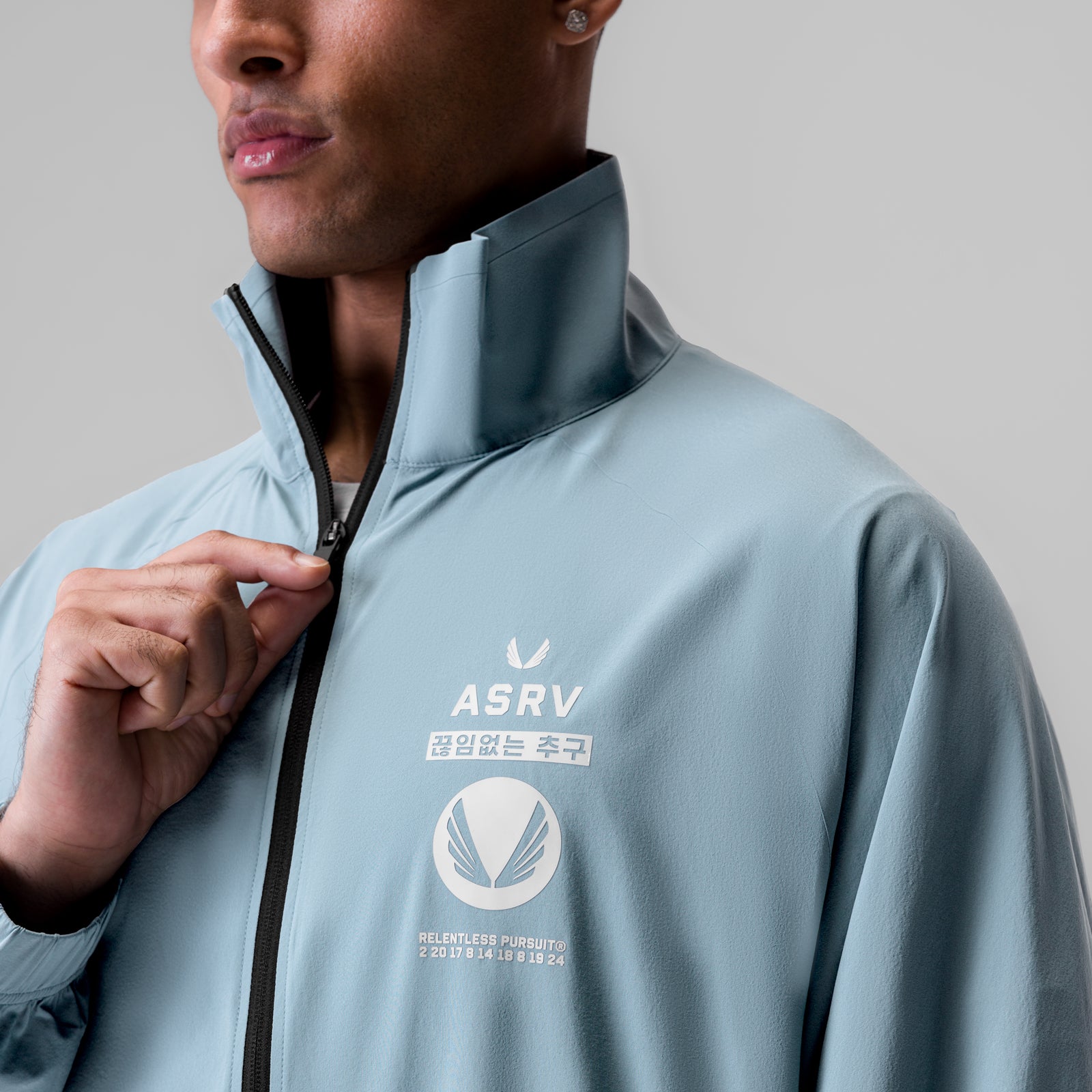 Aerotex Track Jacket in light sky worn by model, front view with collar detail