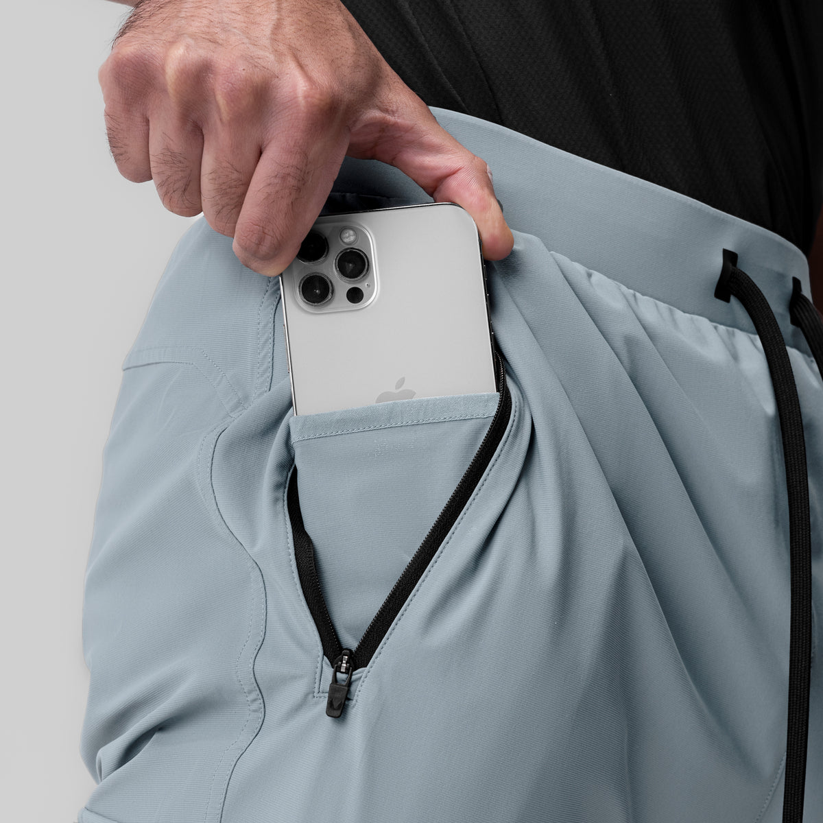 Tetra-Lite Ice Cargo jogger in light sky, model holding white phone in cargo pocket