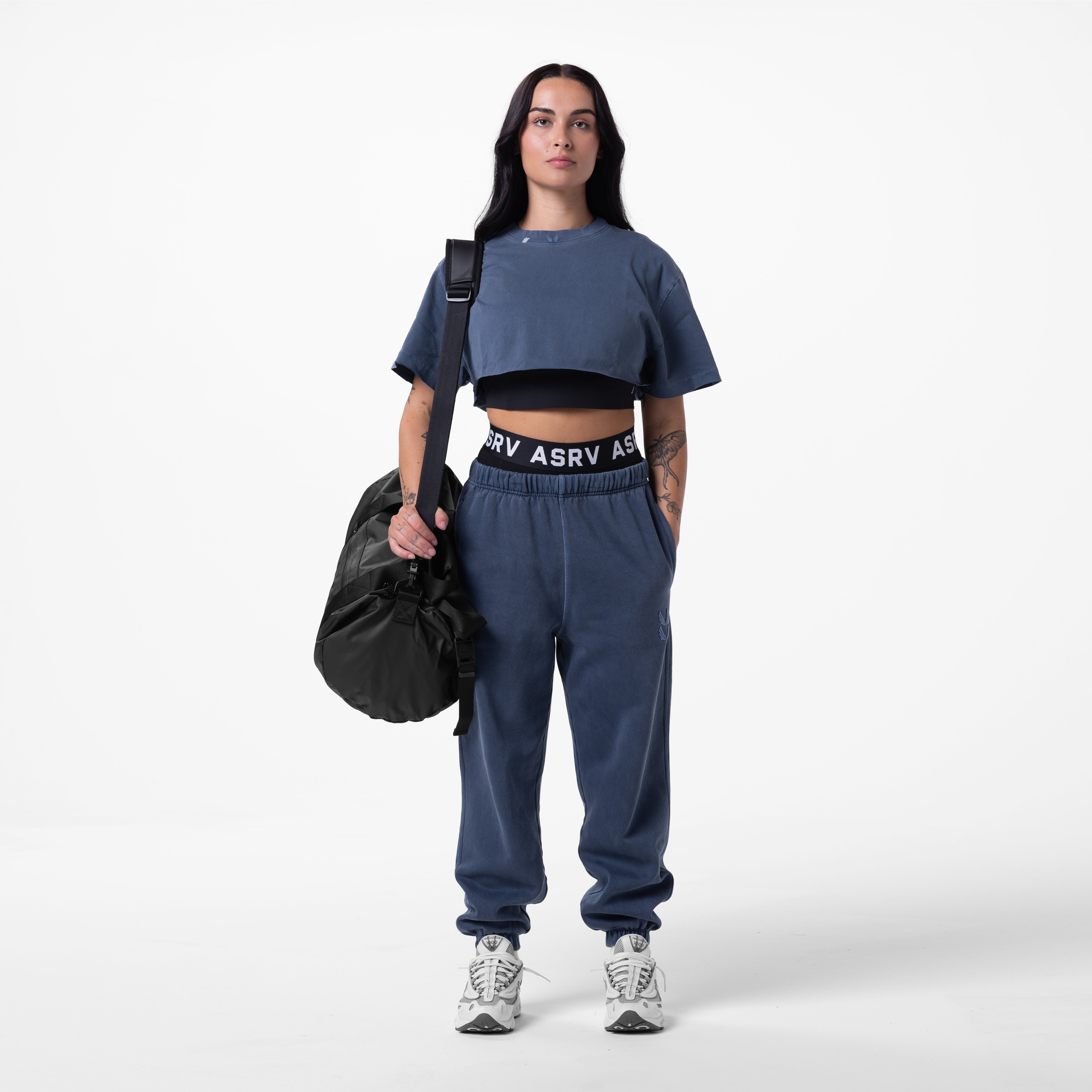 Tech Essential Sweats in faded navy worn with crop tee, model holding black bag