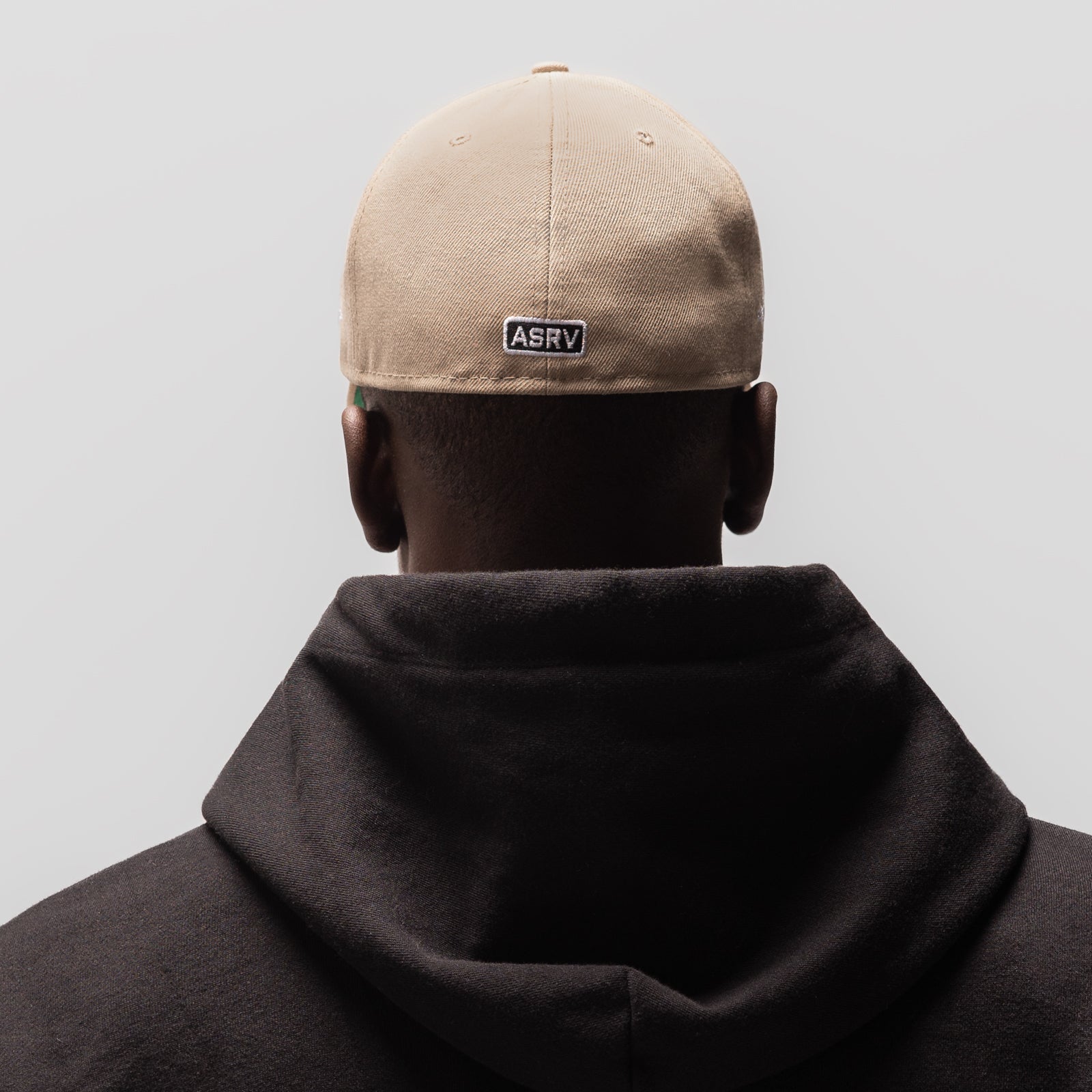 New Era 59Fifty Low Profile Hat in beige and black, worn on model from back view