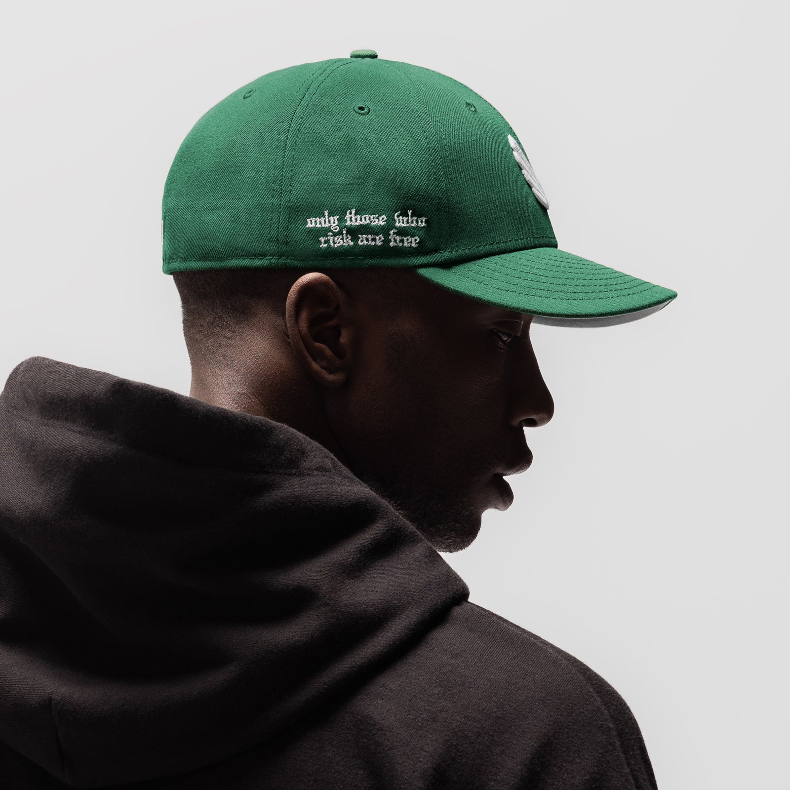 New Era 59Fifty Low Profile Hat in emerald green with white wings logo, worn by model in profile view