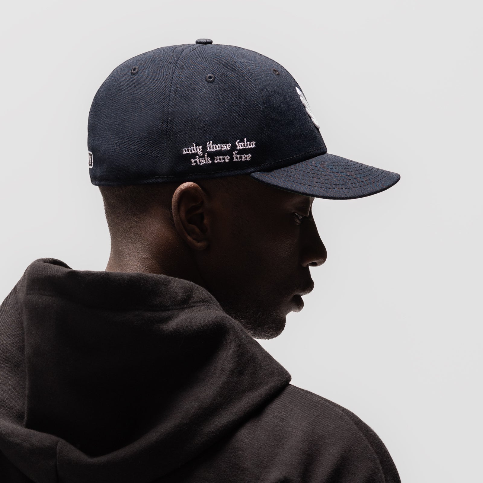 New Era 59Fifty Low Profile Hat in navy with white wings logo, worn by model in profile view