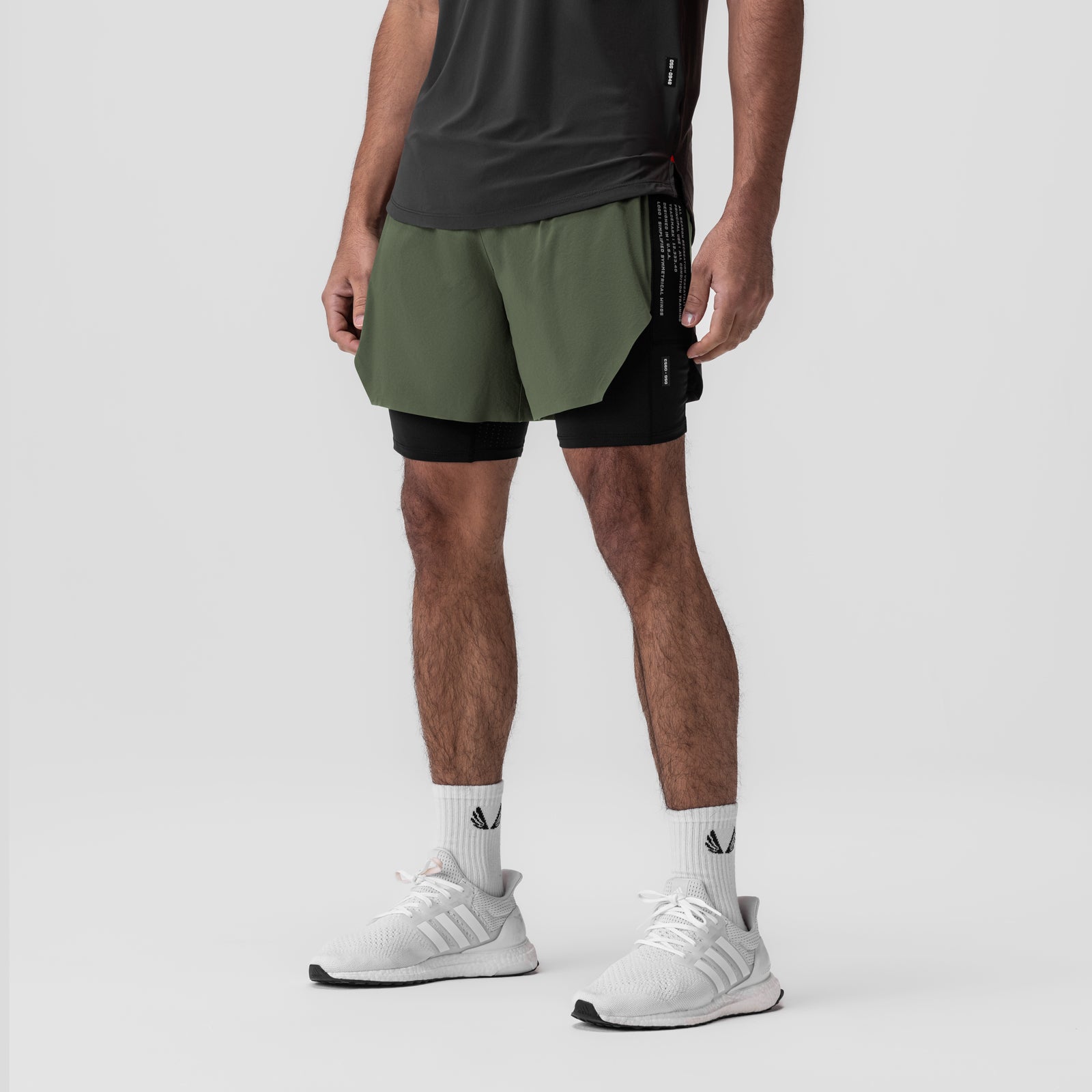 Aerotex Hybrid Liner Short in olive and black, modeled front view with white sneakers