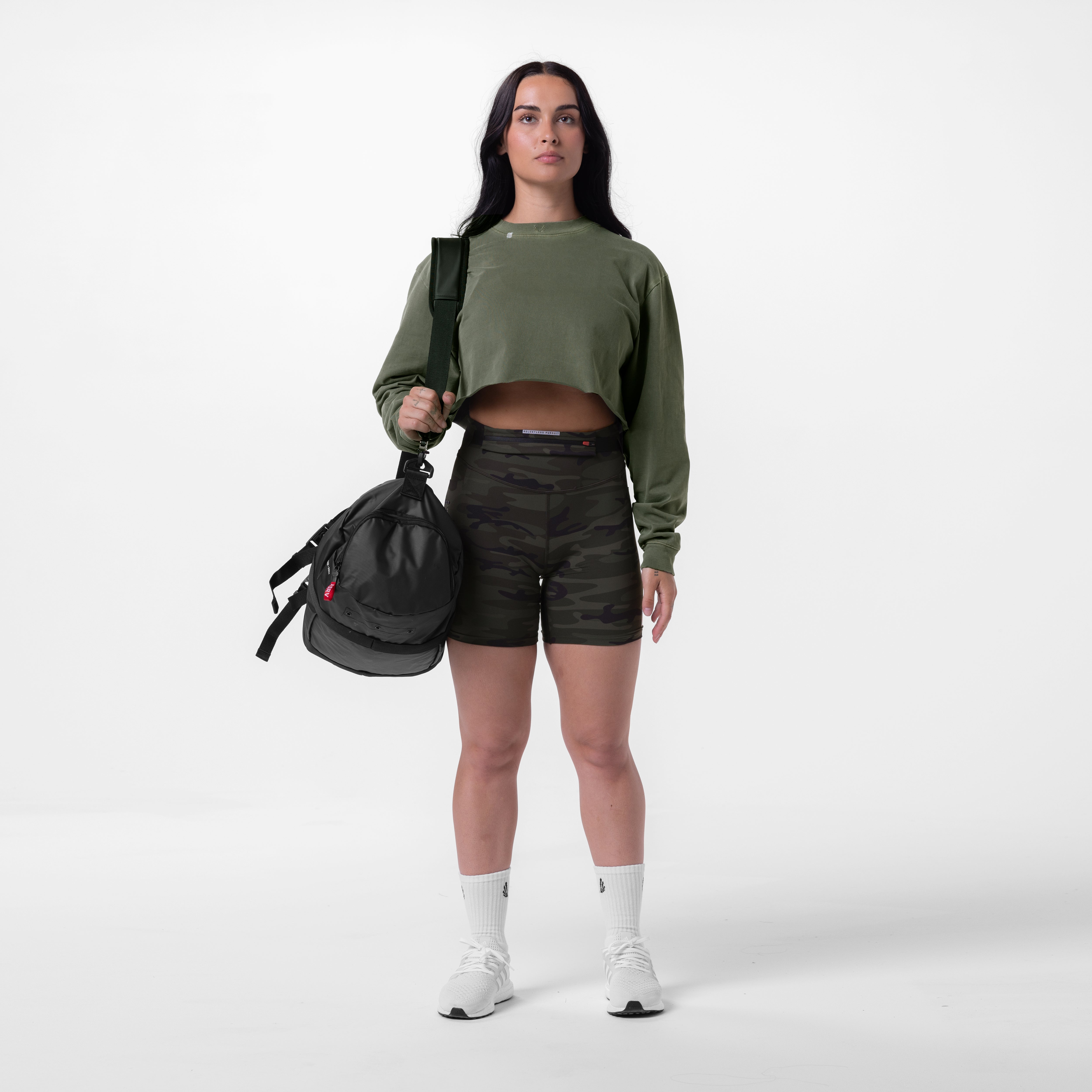 Tech Essential Relaxed Long Sleeve in faded olive worn with black shorts, model holding black backpack