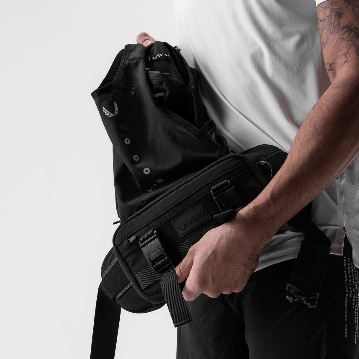 0899. 2-in-1 Packable Run Vest in Black, being held and packed by model