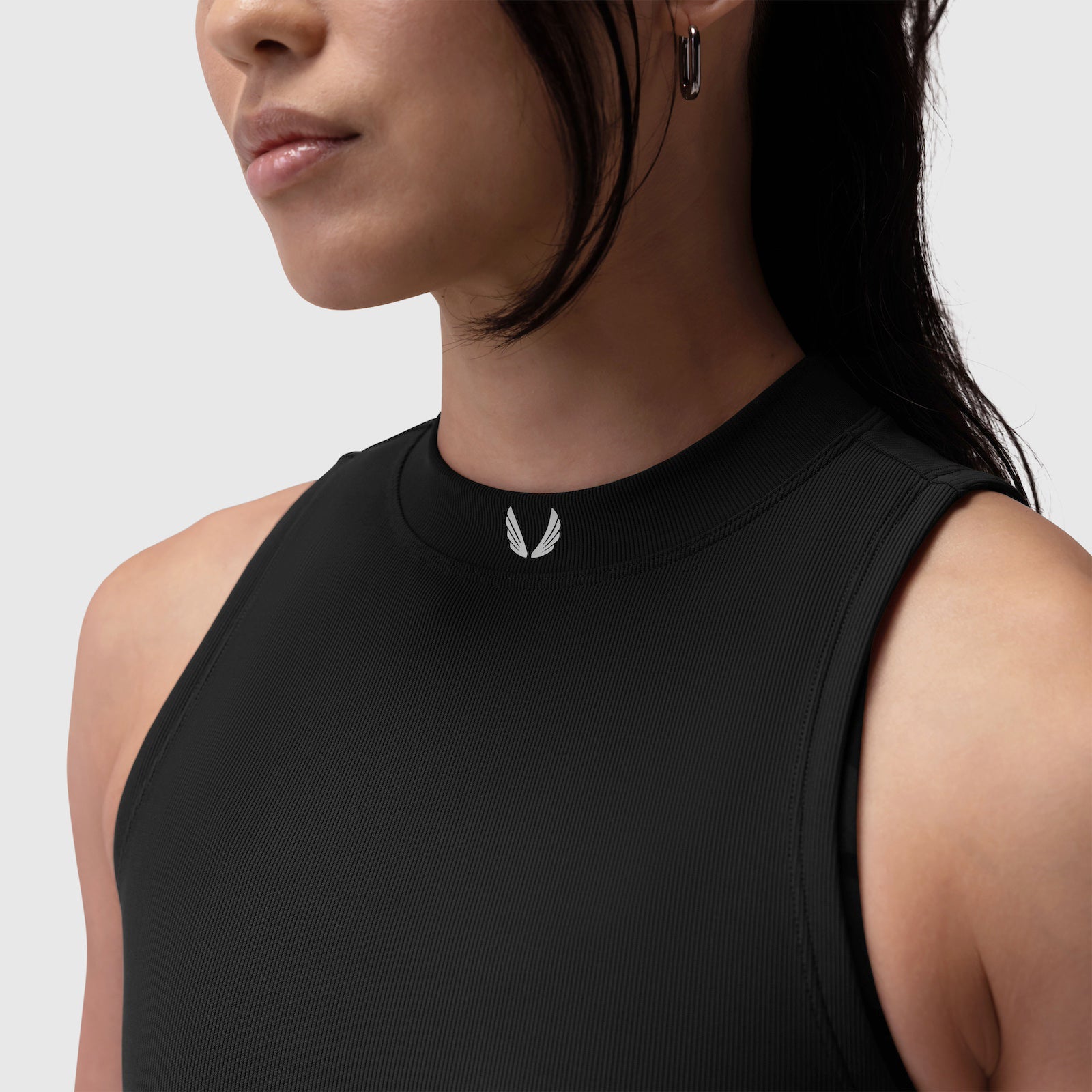 Black LYCRA® ribbed mockneck tank worn by model, side profile view