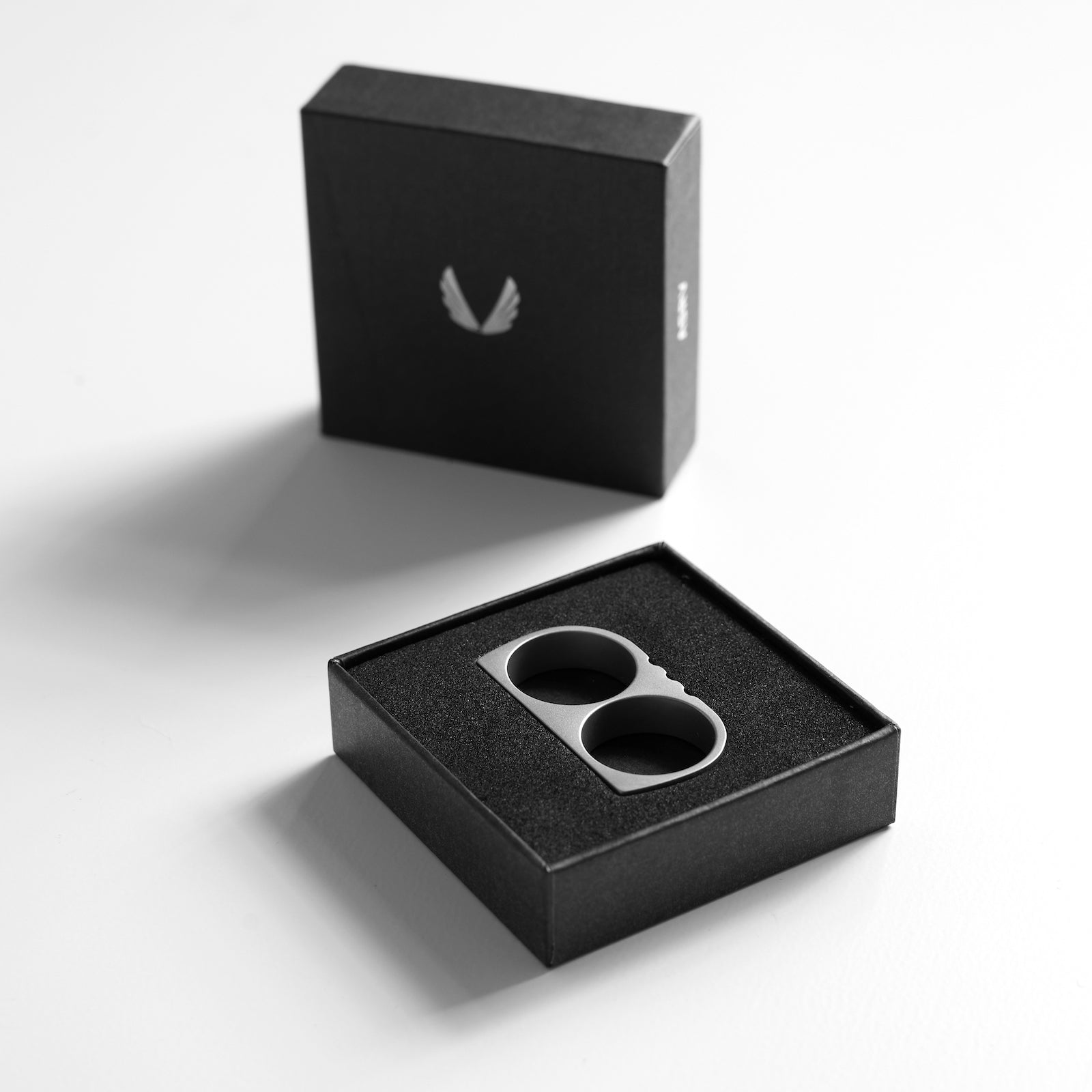 Double Ring stainless steel in silver and black, top view in packaging